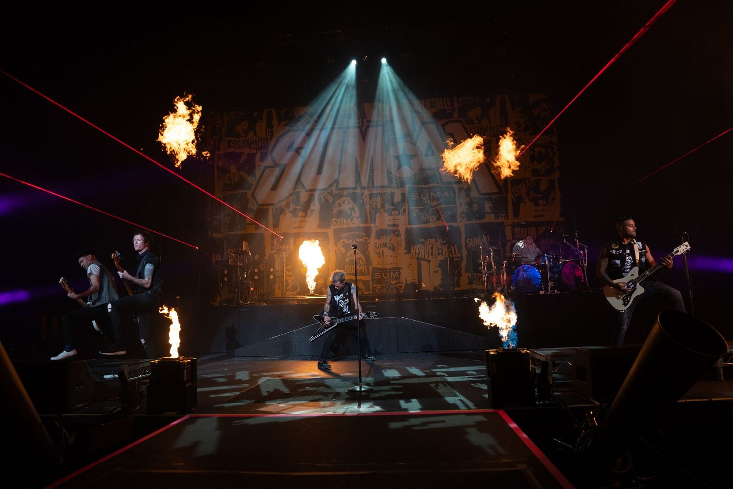Rock concert stage with fire effects and dramatic lighting during intense performance.