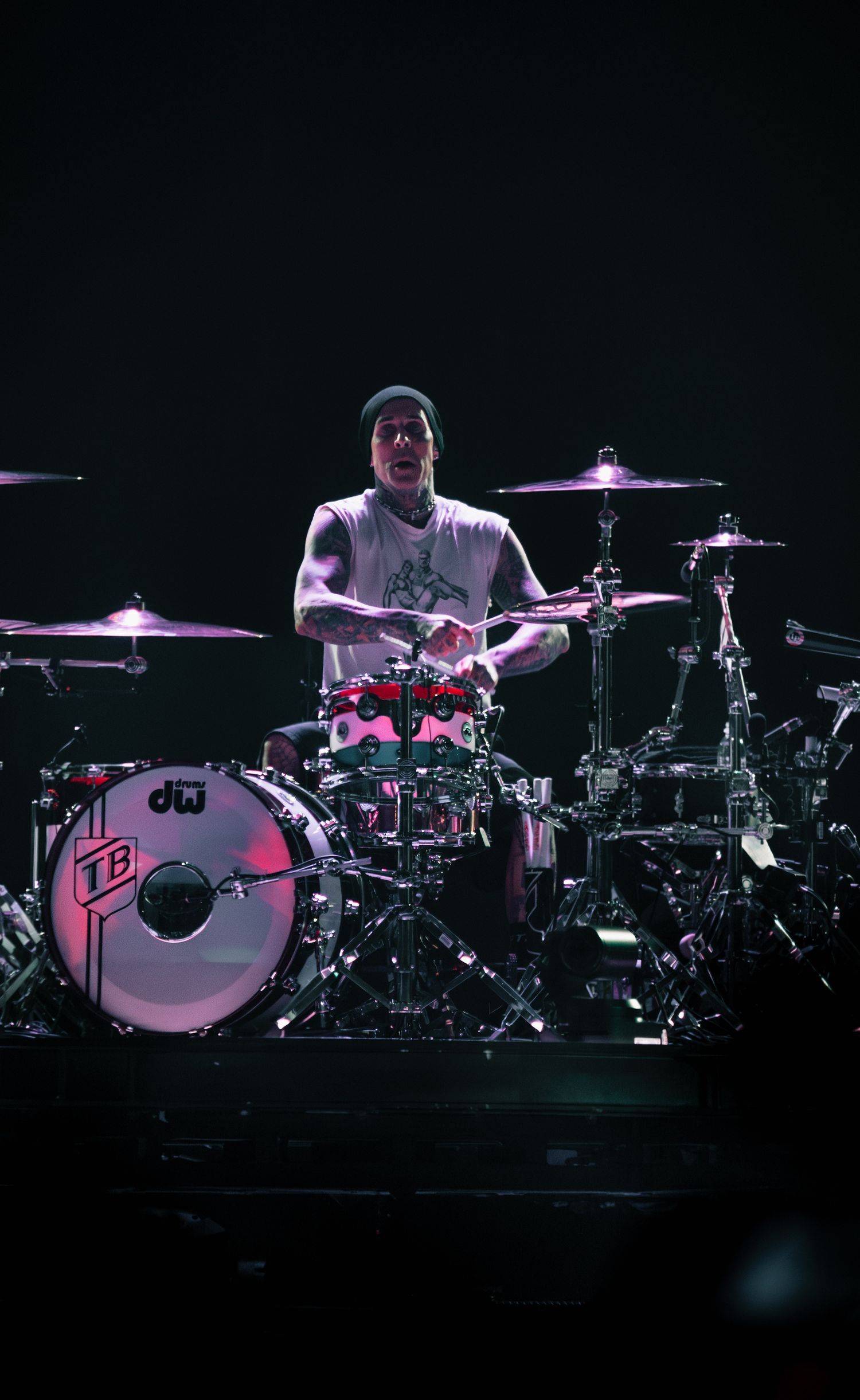 Drummer playing multiple DW drum sets on stage during a performance.