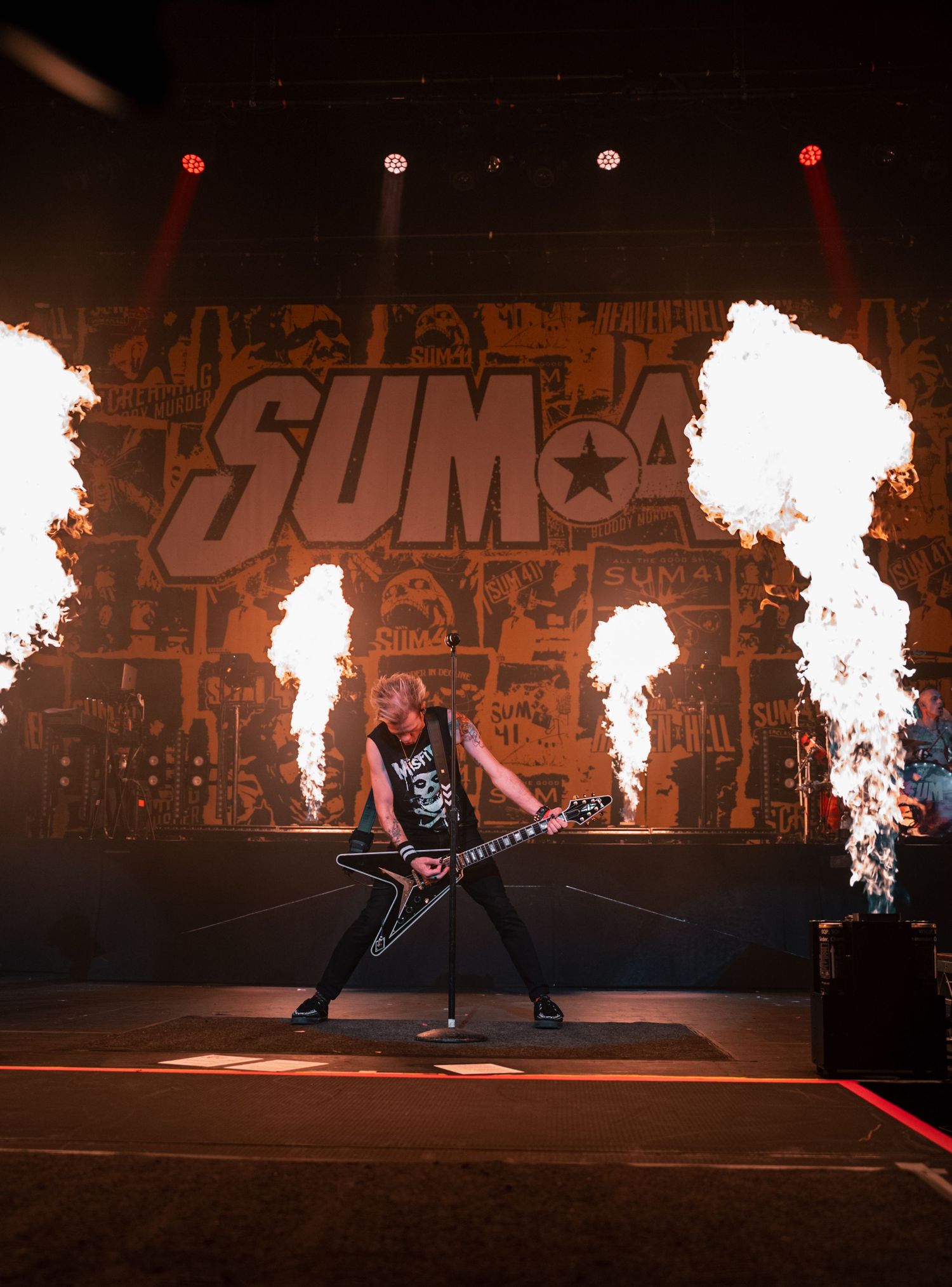 Dramatic concert performance with pyrotechnics and flame effects on stage.