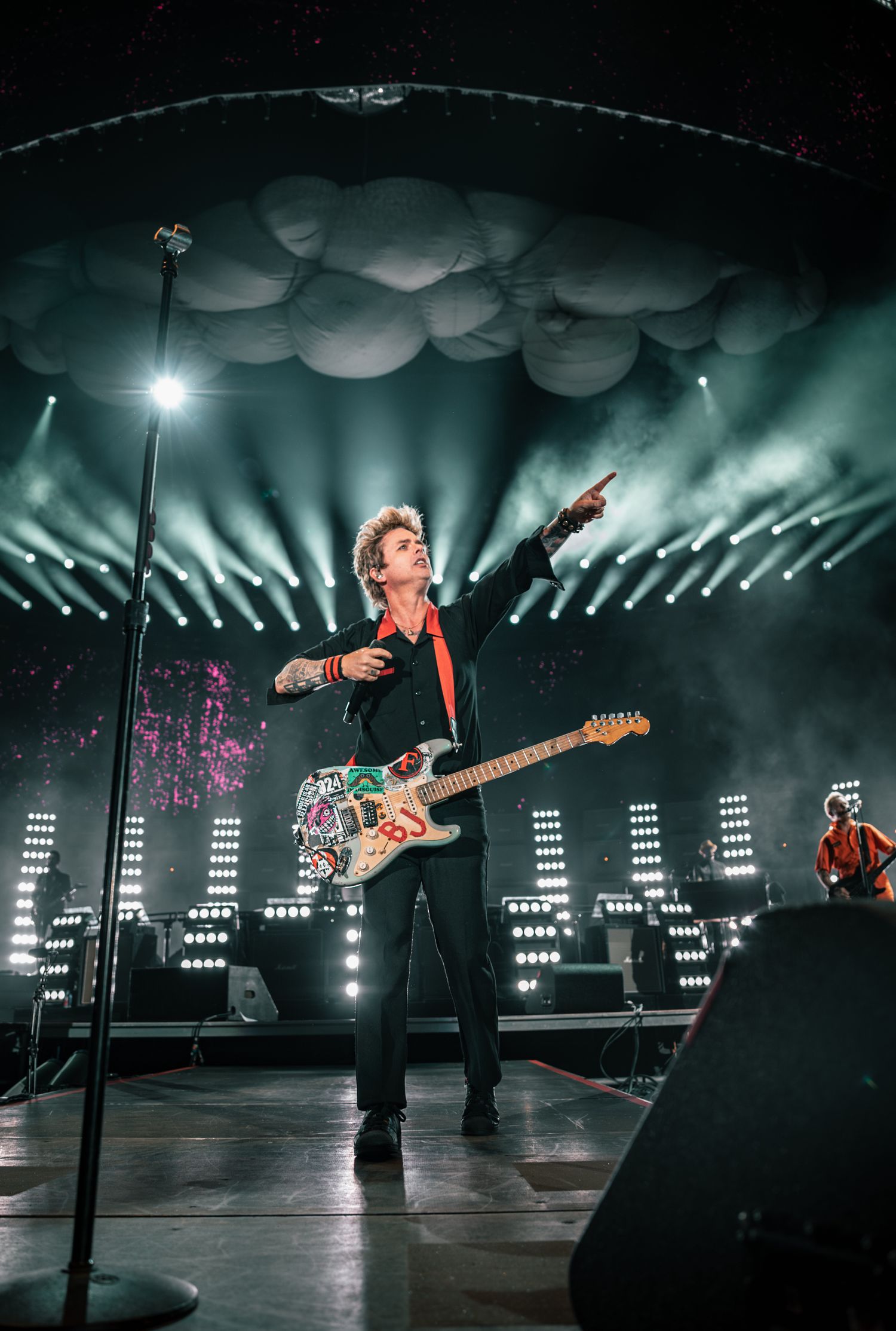 Wide concert stage view with geometric lighting design and dramatic performance silhouettes.