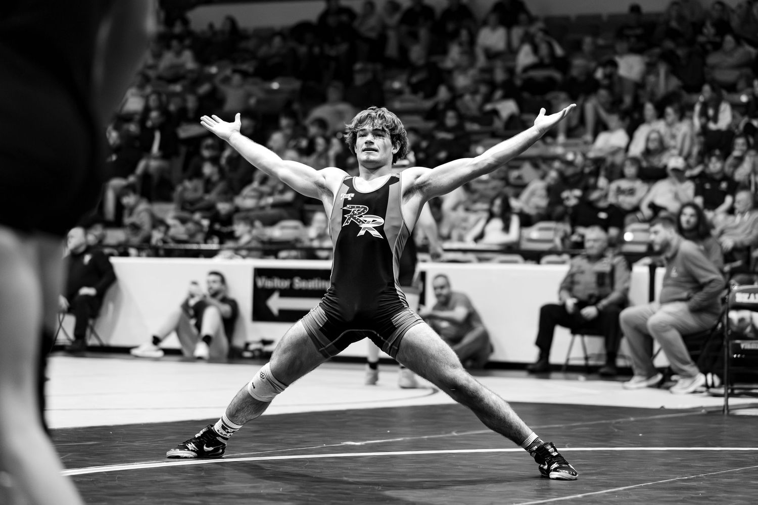 A series of black and white wrestling match photos showing athletes in various competitive positions on the mat.