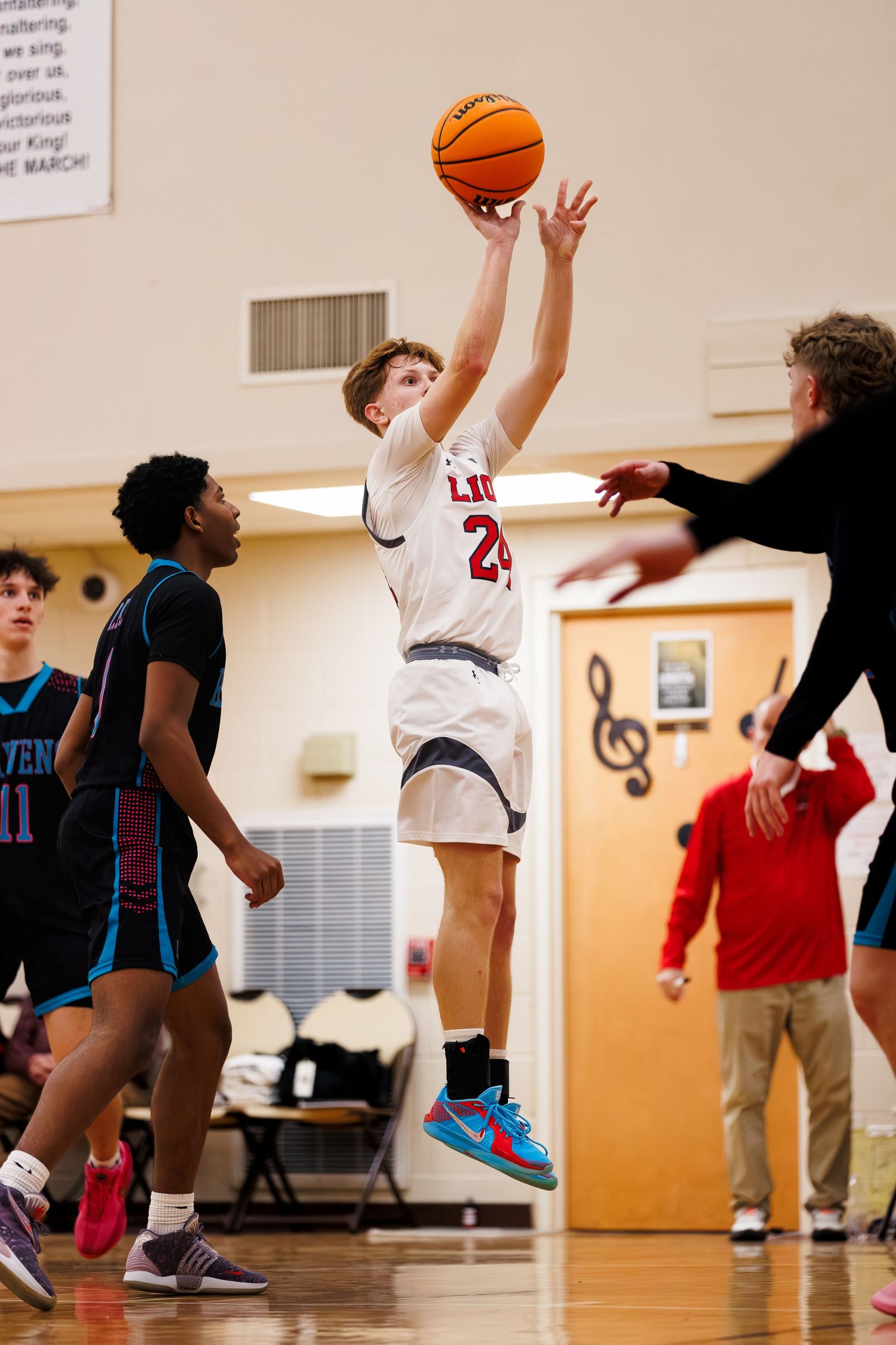 Basketball players compete in an indoor gym game showing various action shots of jumping and shooting movements.