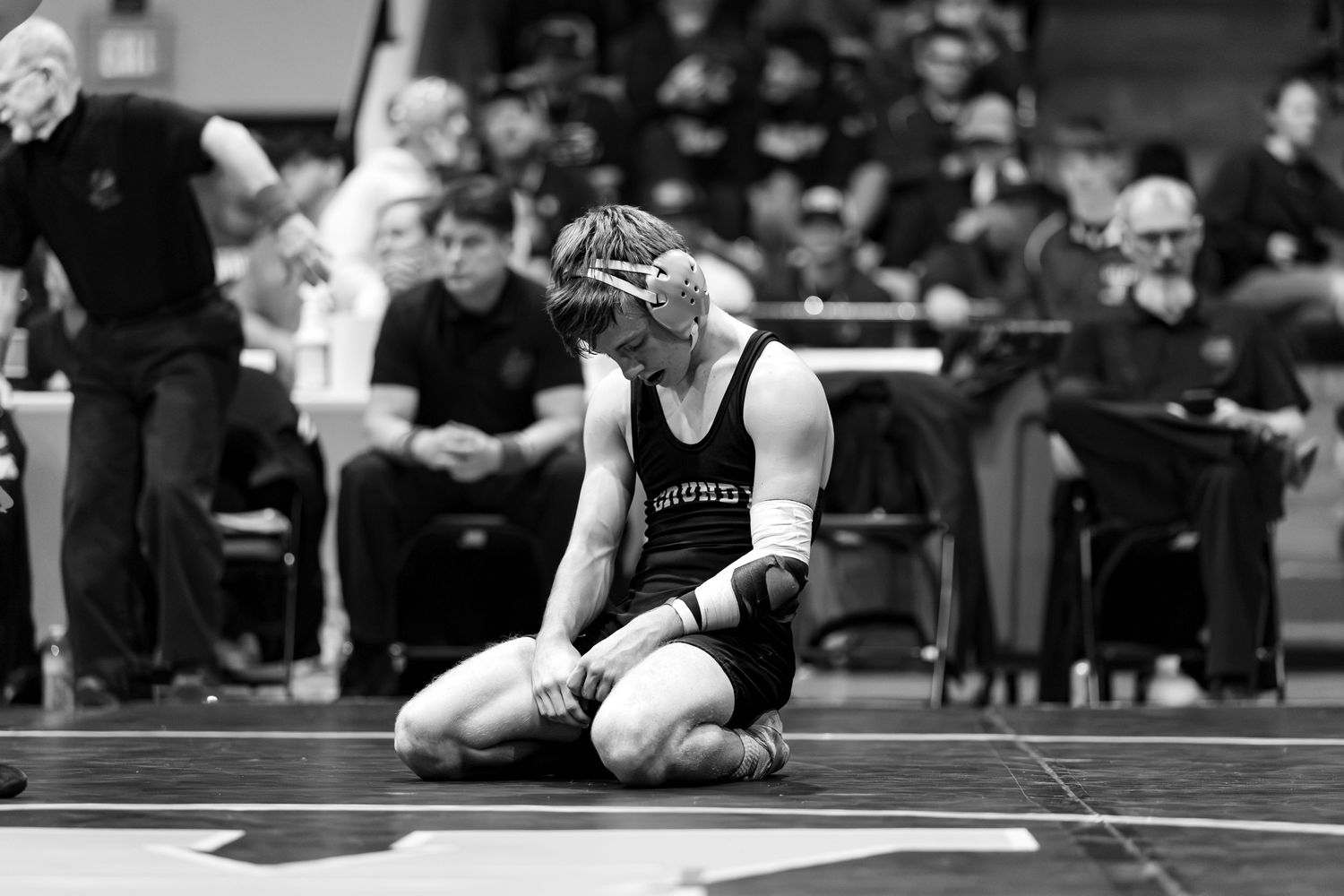 A sequence of black and white wrestling match photos showing various competitive moves and holds on the mat.