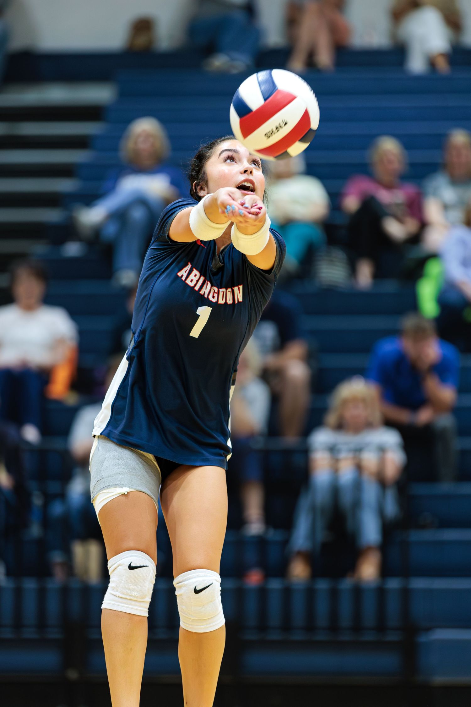 Volleyball player in black uniform diving to save the ball during an intense match.