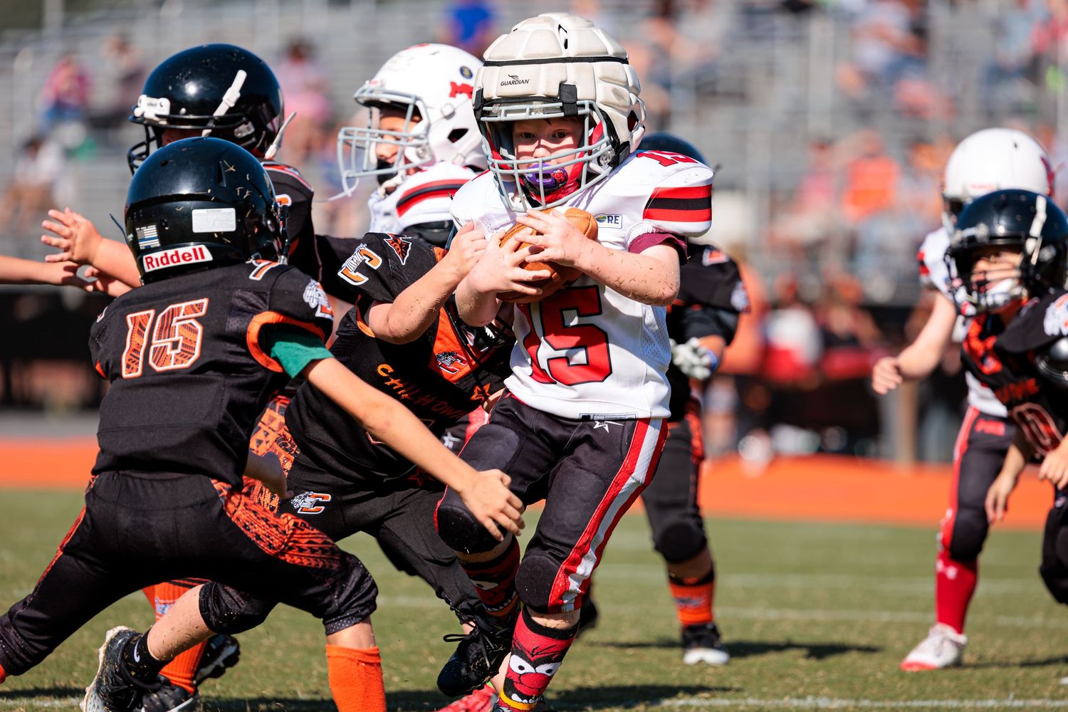 Football players colliding in hard-hitting tackle during competitive game.