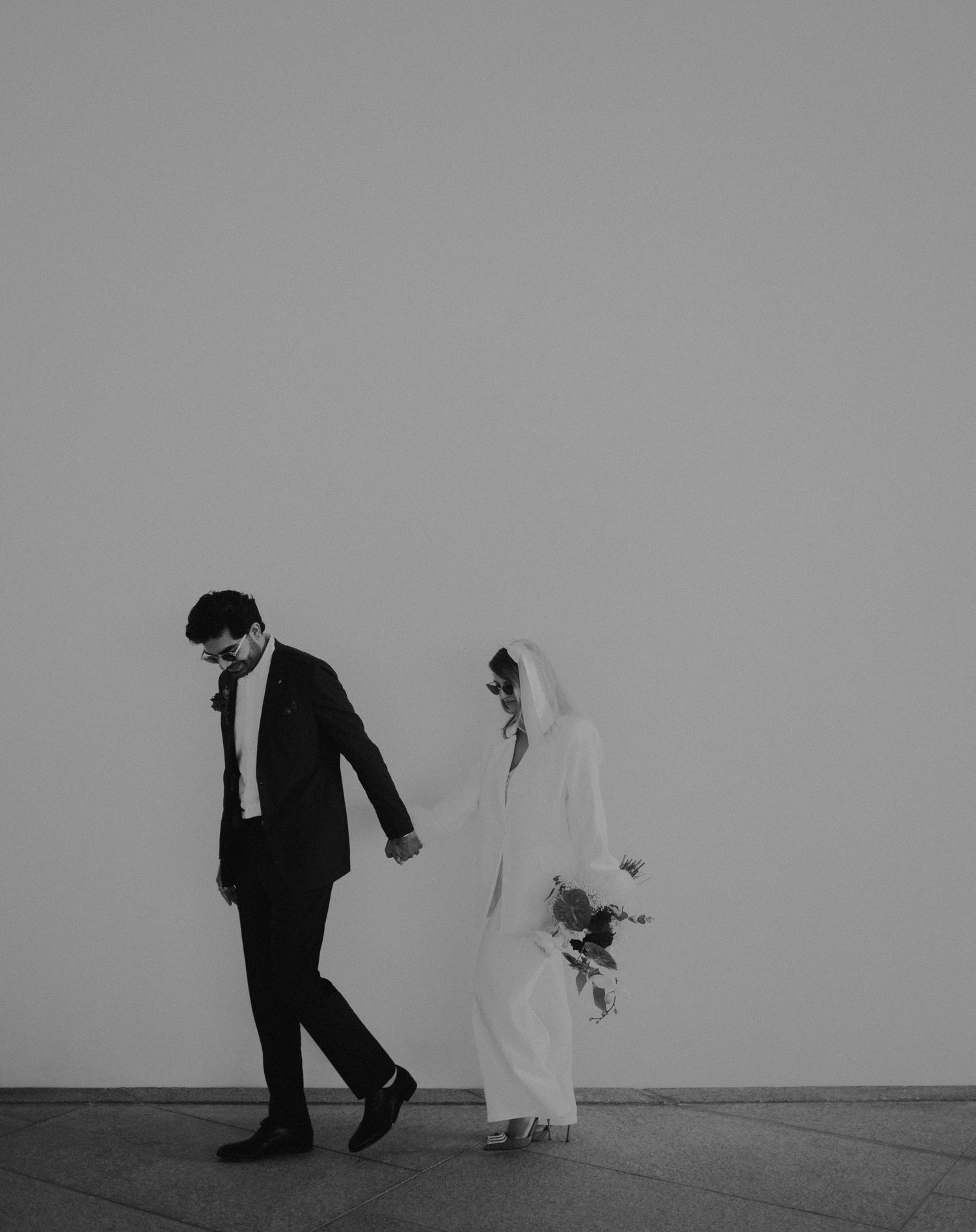 Minimalist black and white wedding photo with couple in artistic silhouette.