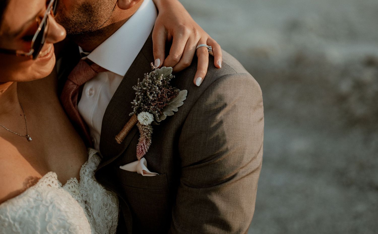 Romantic couple sharing an intimate moment at sunset in a desert landscape with glowing lanterns.