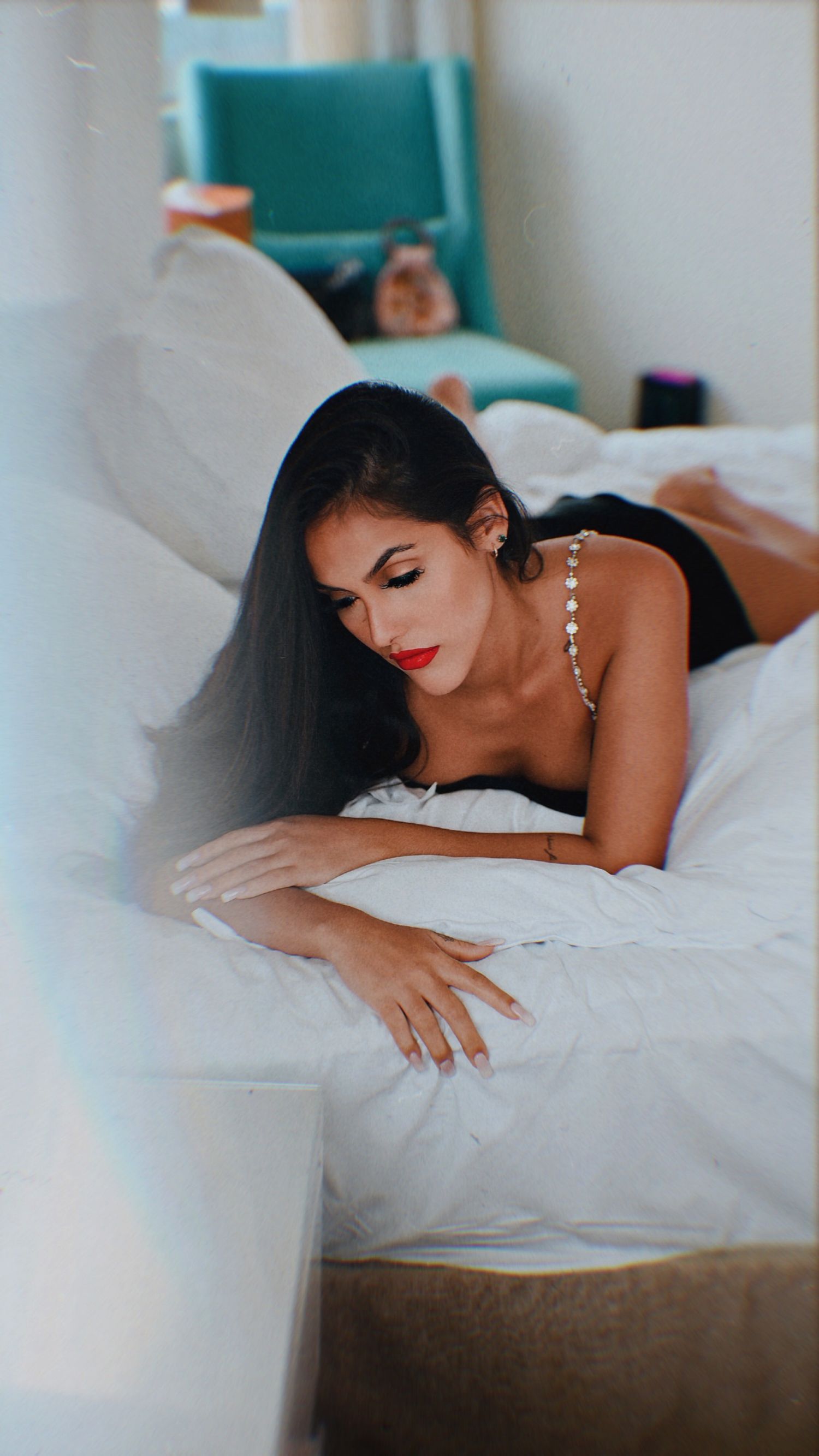 Elegant boudoir photography with soft lighting and white bedding.