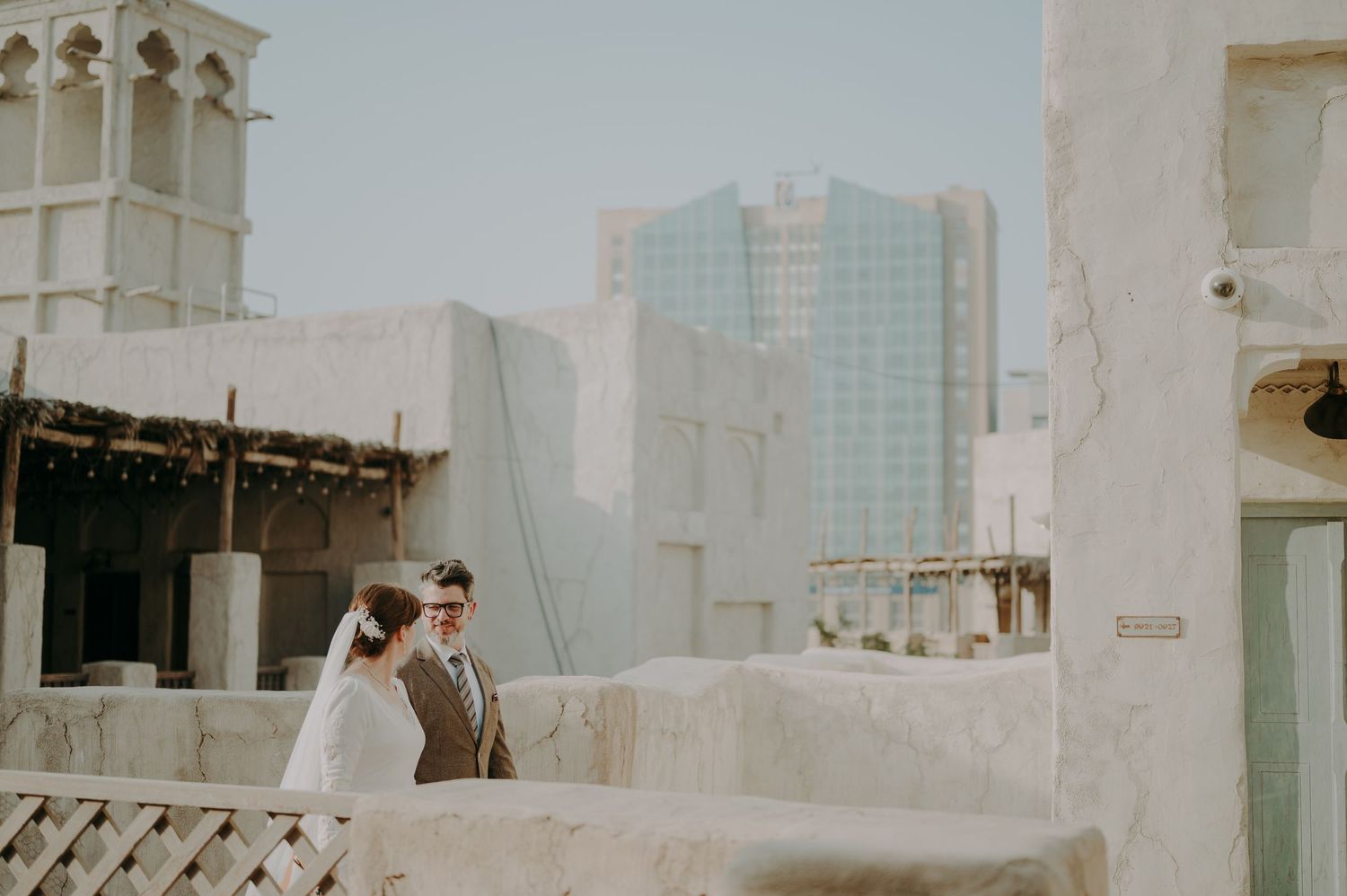 White stucco walls and arched doorways create a rustic Mediterranean architectural backdrop.