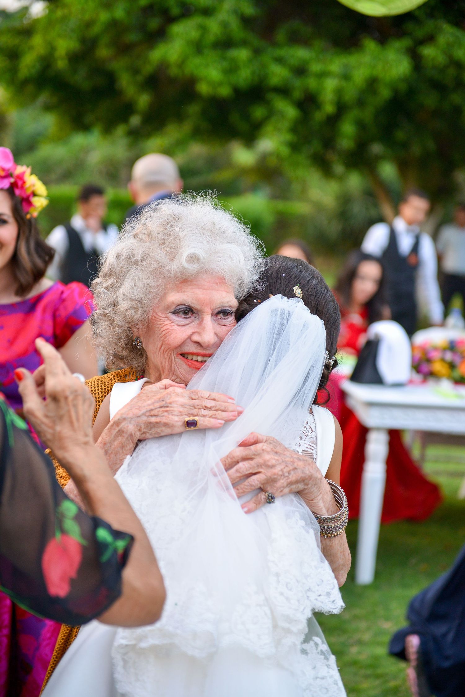 Emotional wedding celebration moments captured with guests in an outdoor garden setting.