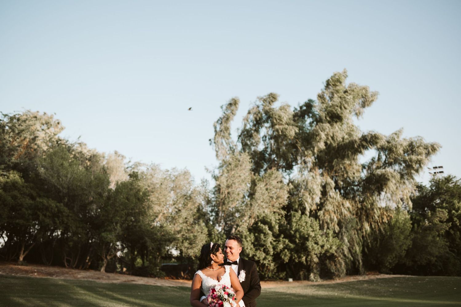A scenic outdoor photo session on a golf course with trees in the background.