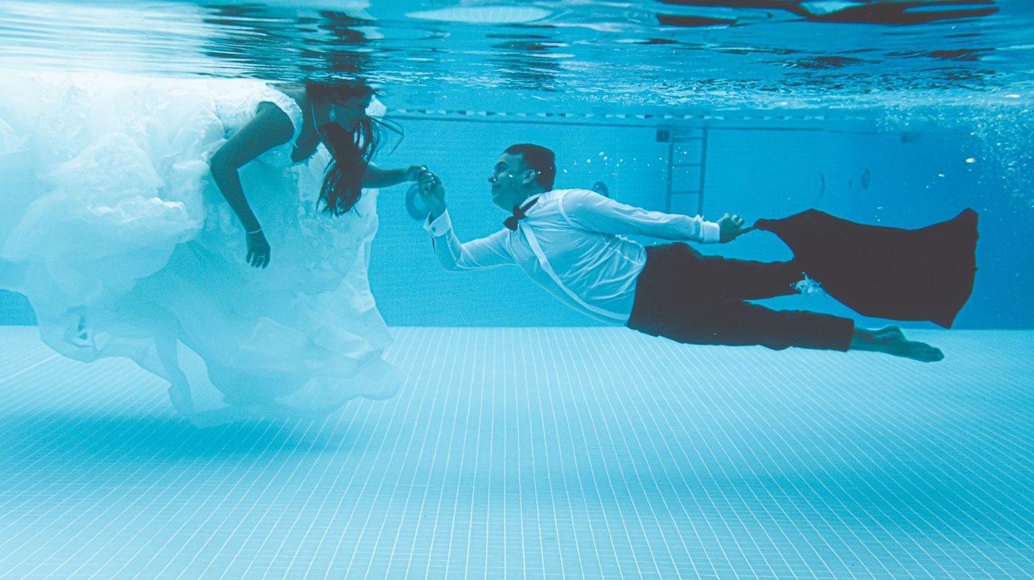 Underwater photography sequence capturing swimmers moving through a bright blue pool.