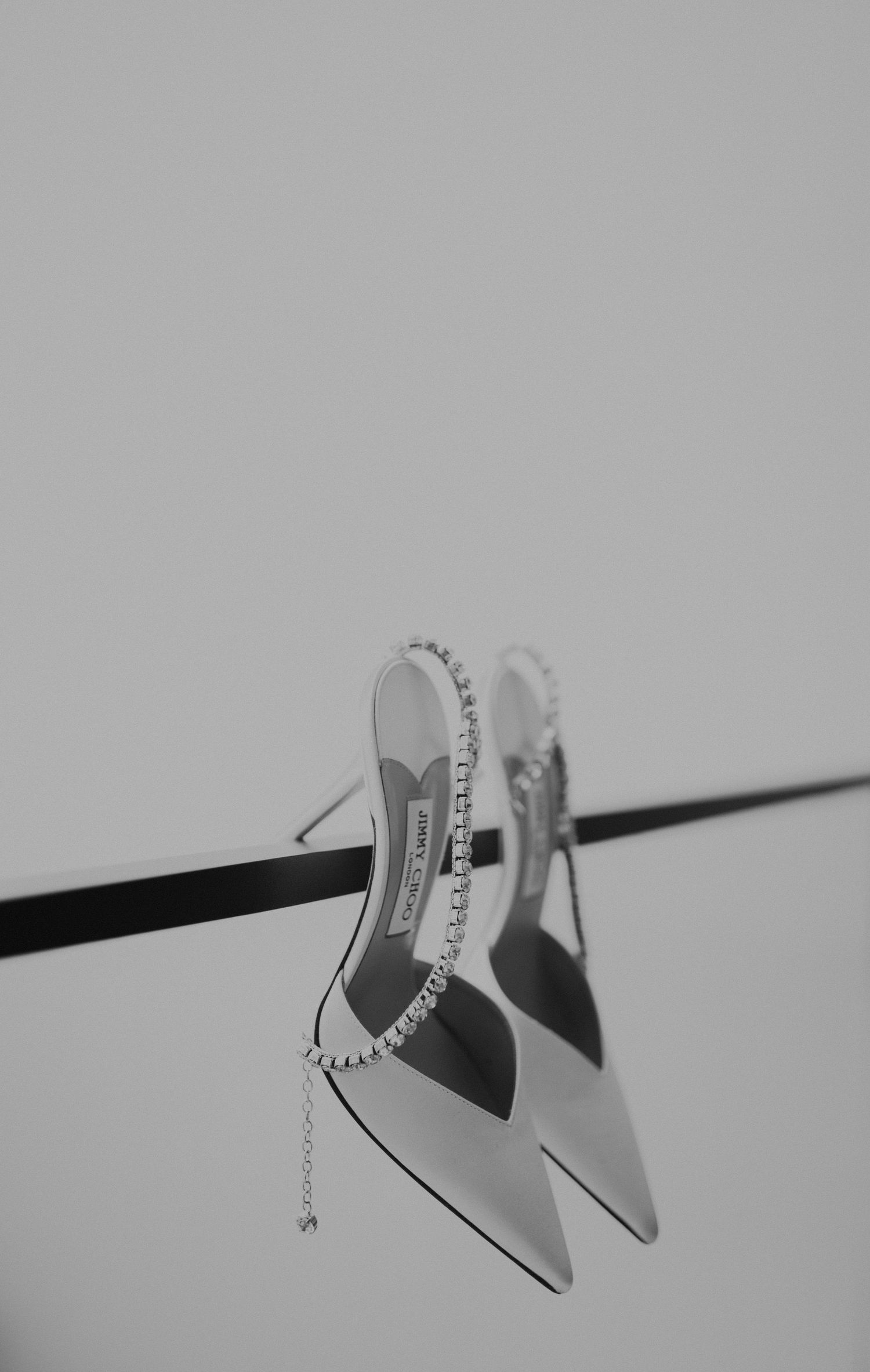 Elegant bridal shoes with crystal details arranged in a minimalist black and white composition.