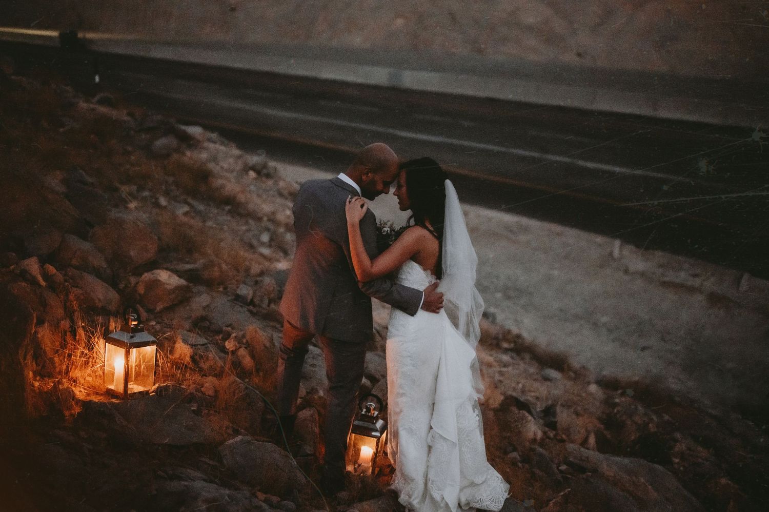 Romantic evening scene with lanterns glowing against rocky terrain.