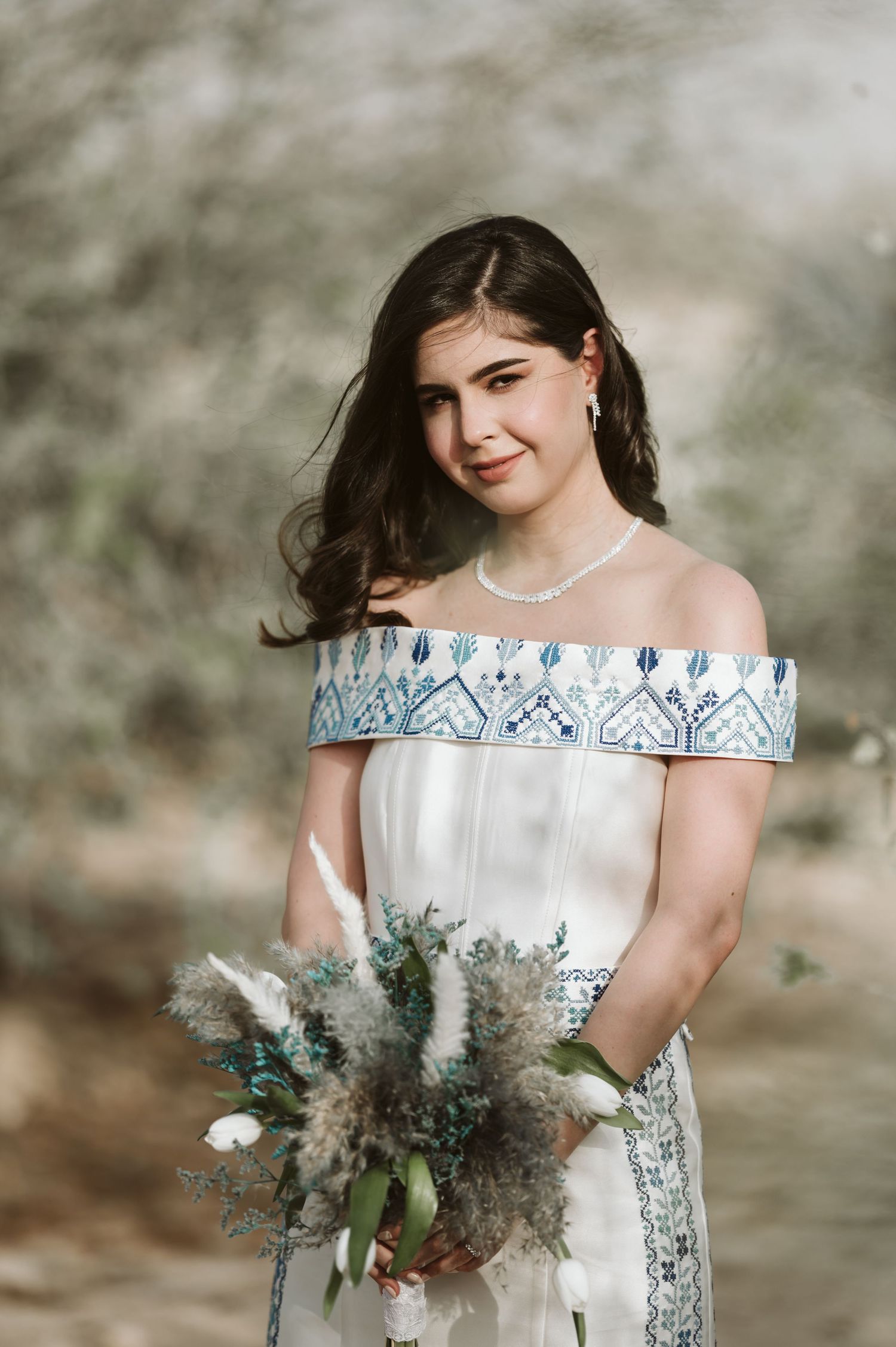 Bridal portraits featuring a white off-shoulder gown with blue trim and rustic bouquet.