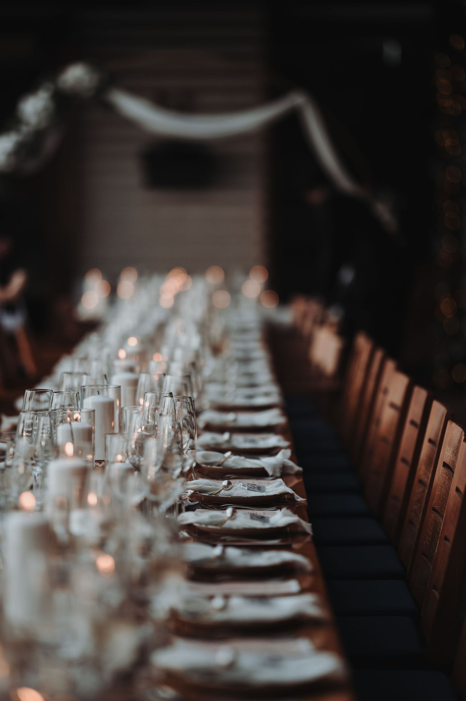 Elegant table setting with glassware and place settings in a dimly lit restaurant.