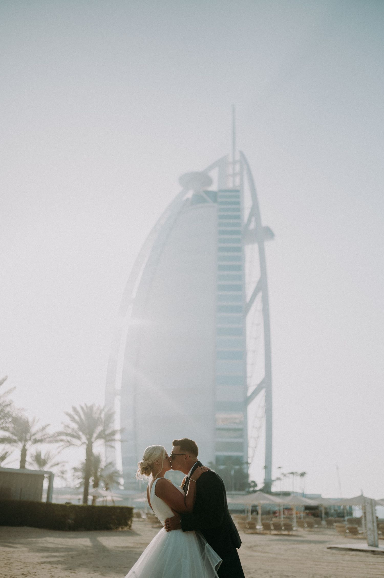 Intimate wedding moment captured with Dubai's famous Burj Al Arab hotel in the distance.
