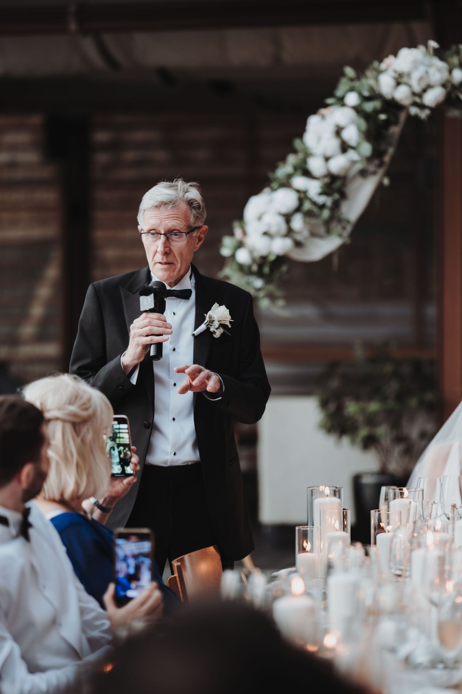 Speaker in formal attire giving a toast at an elegant reception.