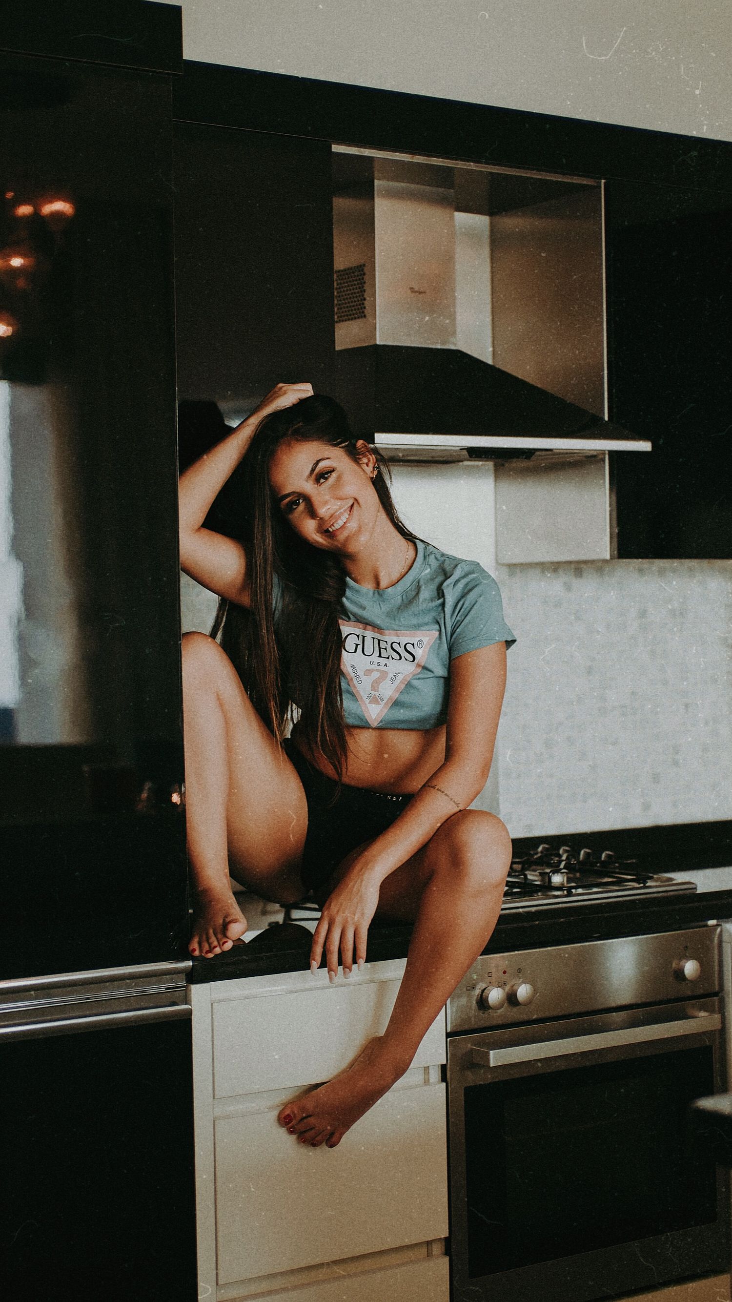 Artistic portrait session featuring relaxed poses in a contemporary kitchen setting.