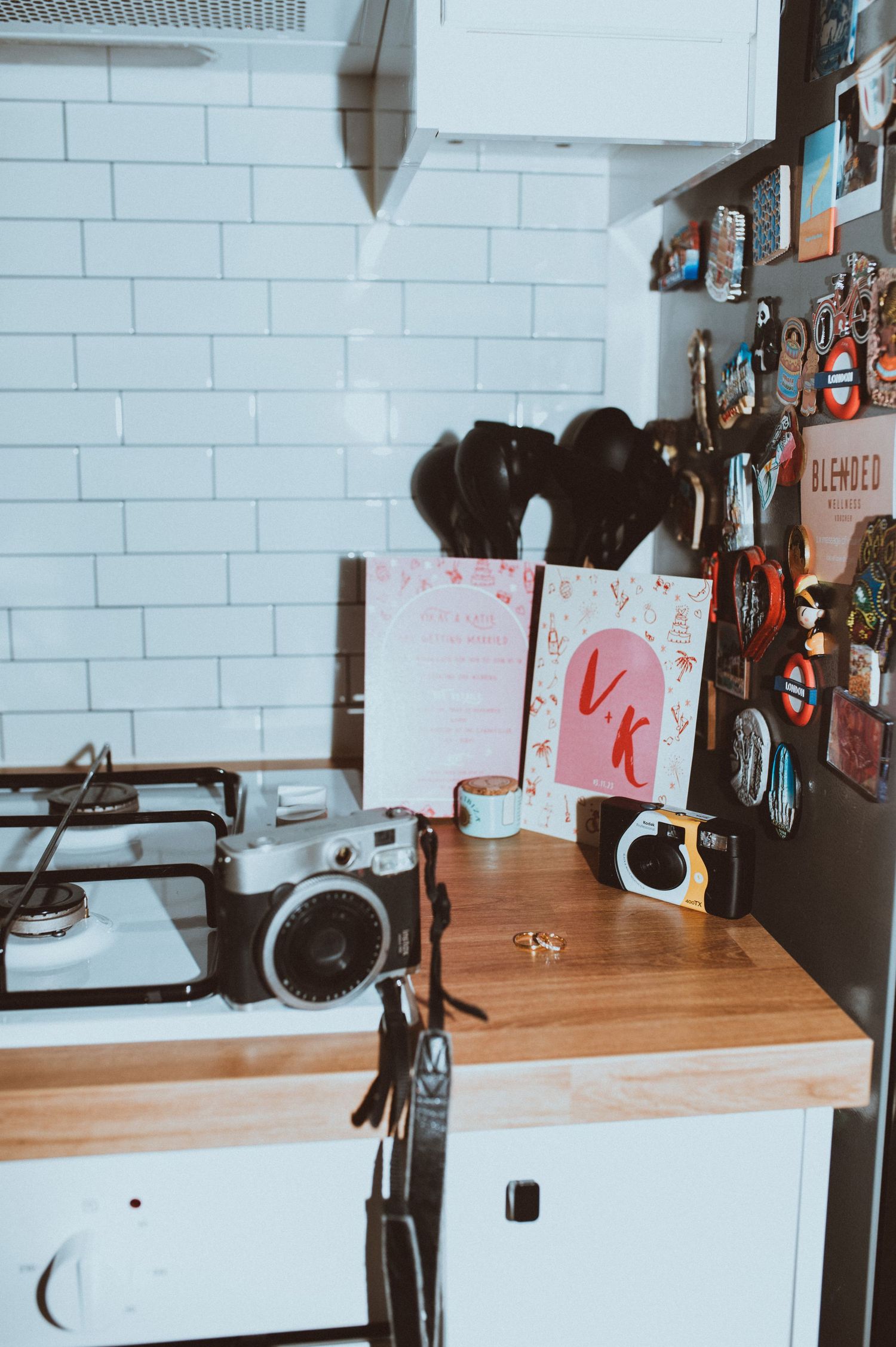 Interior view of a modern kitchen with white brick walls and wooden countertops displaying various cooking utensils.