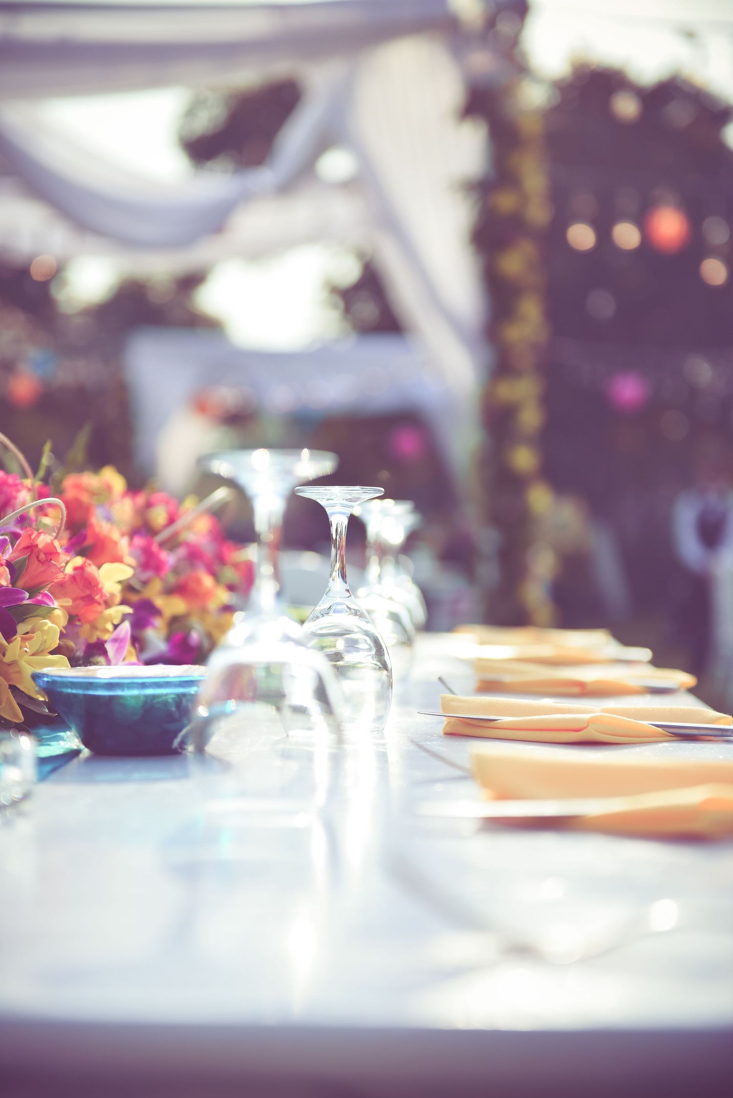 Elegant table settings with wine glasses and floral centerpieces at an upscale event.