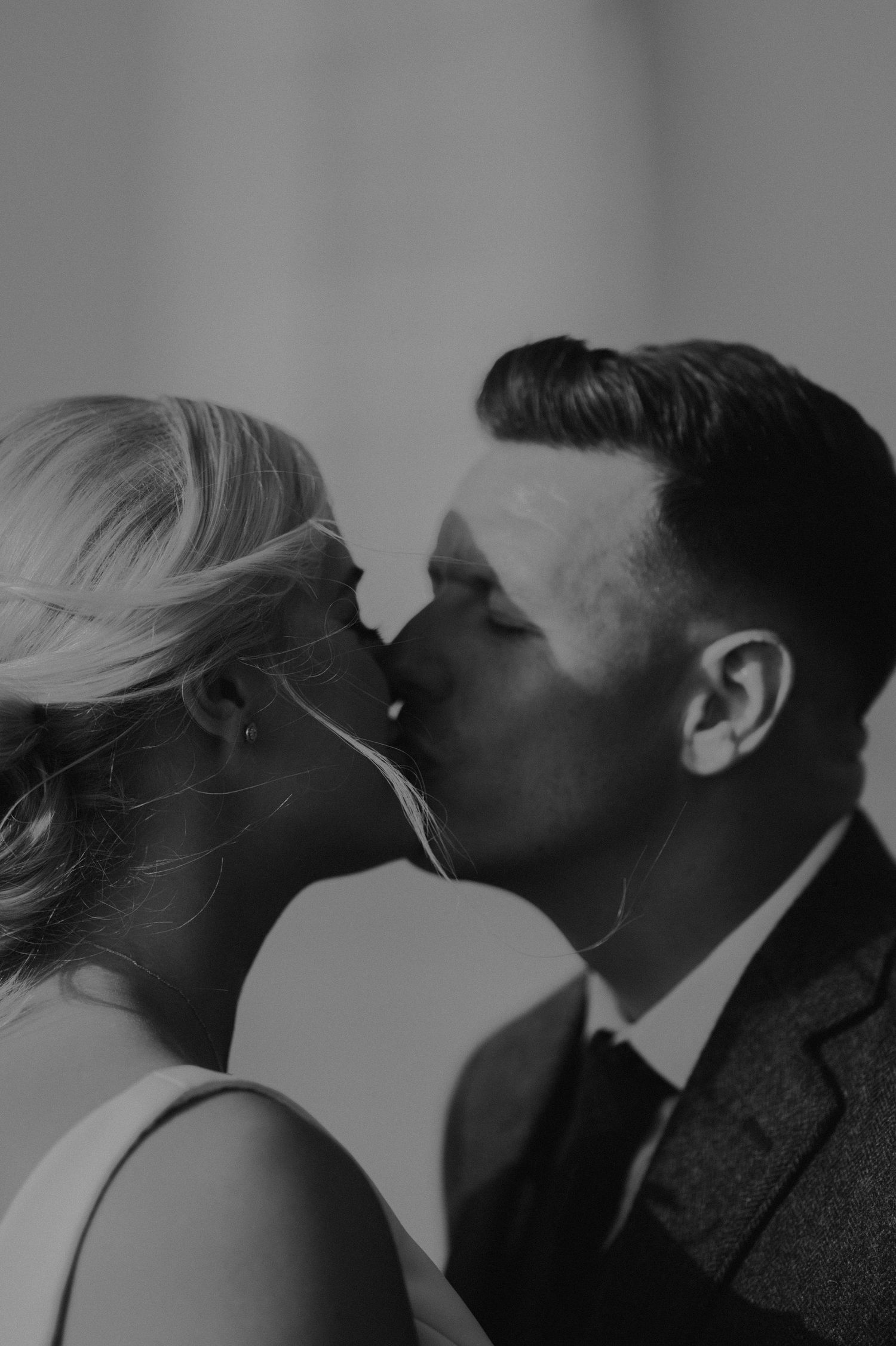 An artistic black and white silhouette captures an intimate wedding moment.