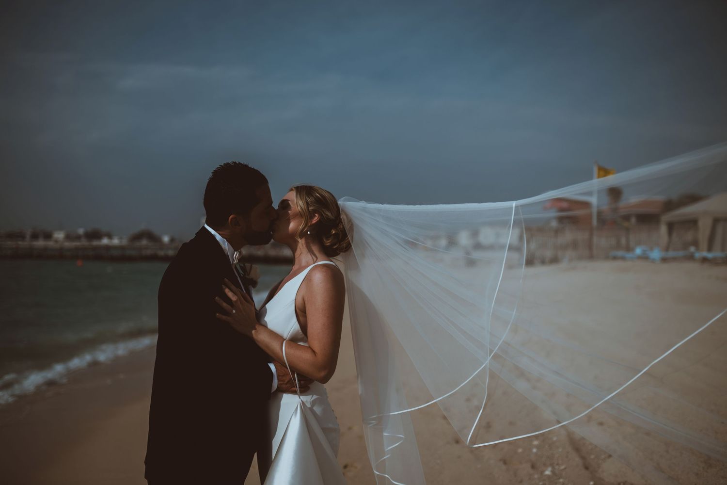 Dramatic seaside wedding photography sequence with flowing veil in the wind.