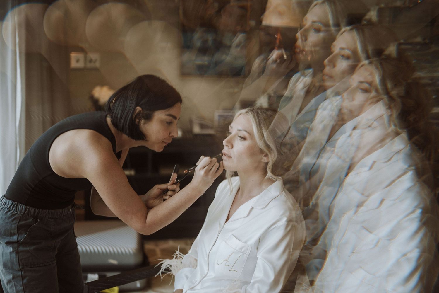 A behind-the-scenes moment of wedding preparation in a room with wedding dresses.