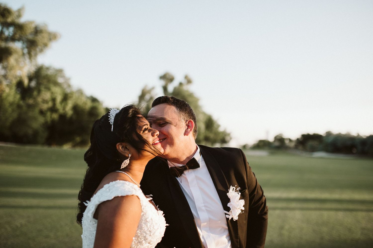 Couple sharing a tender moment together in a sunlit outdoor setting.