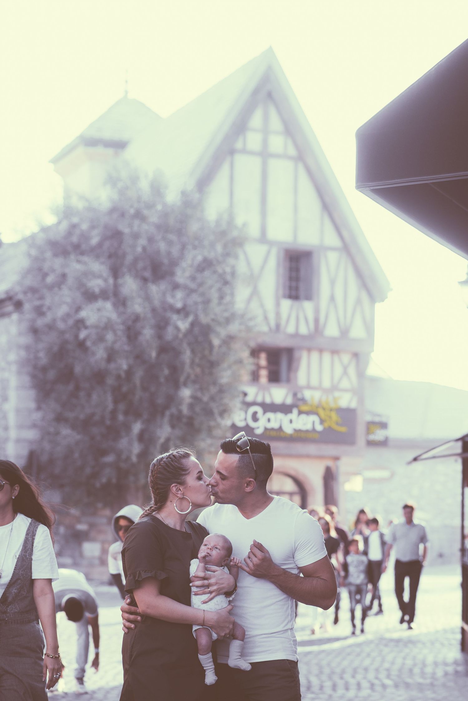 A series of vintage photos showing people embracing and interacting outdoors near Tudor-style buildings.