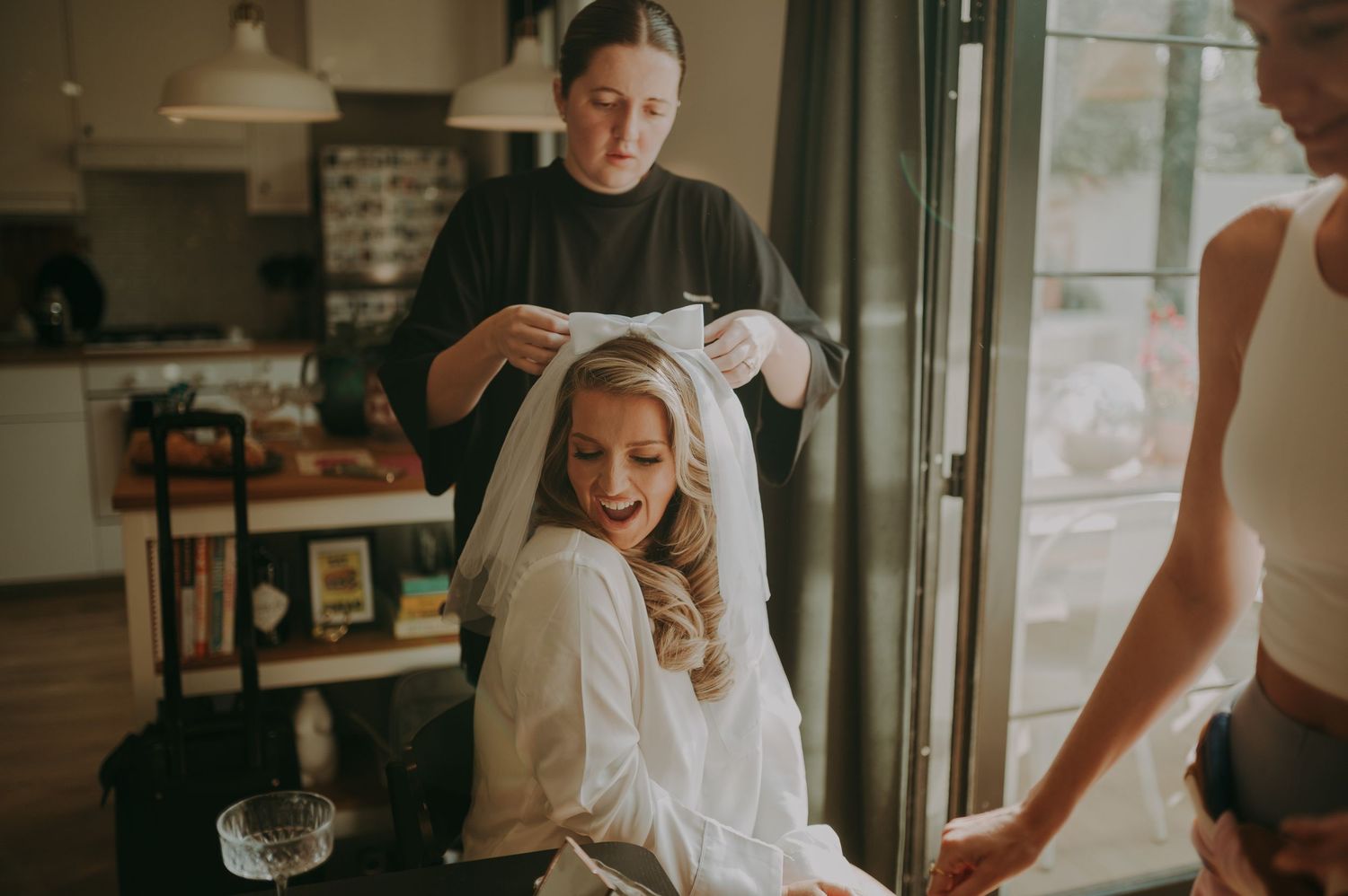 Wedding preparation scene in a bright, modern space with natural lighting.