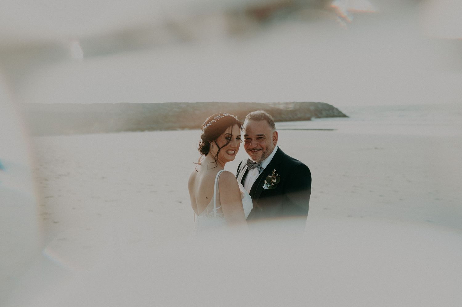 Intimate wedding portraits captured against a misty coastal backdrop.