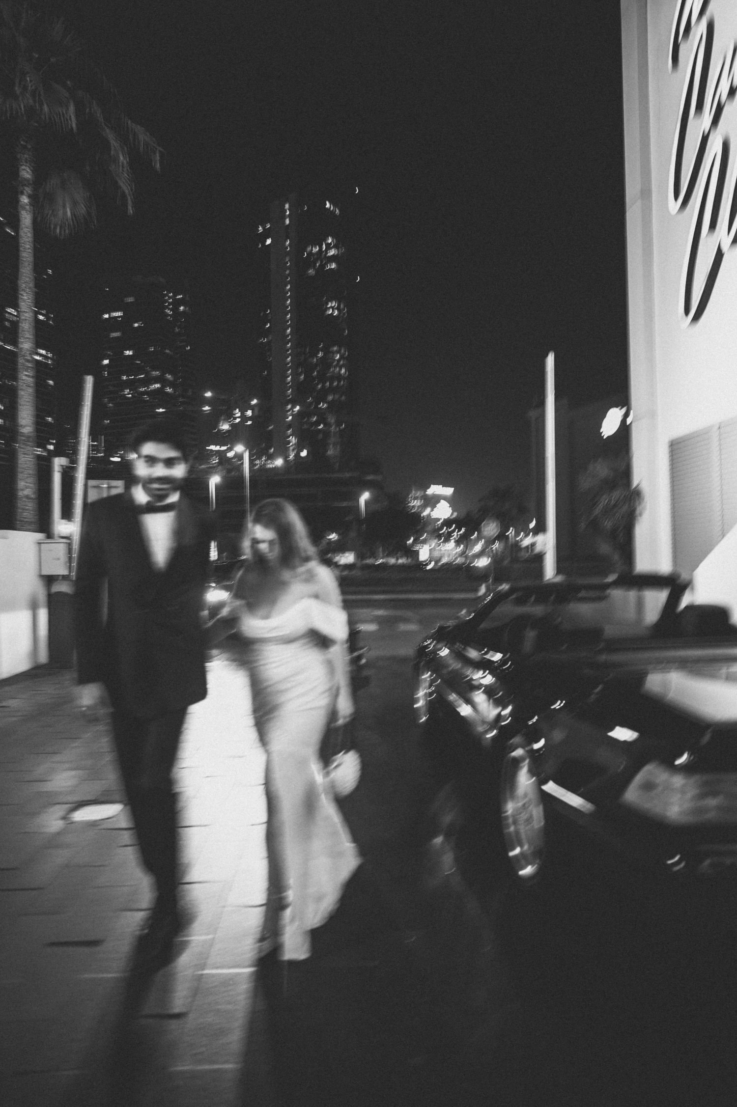 Blurred nighttime urban scene with city lights and moving figures.