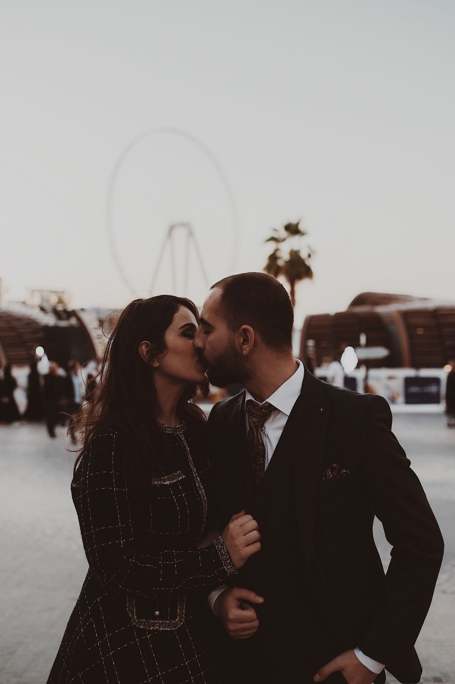 Couple in winter attire sharing tender moment against snowy background.