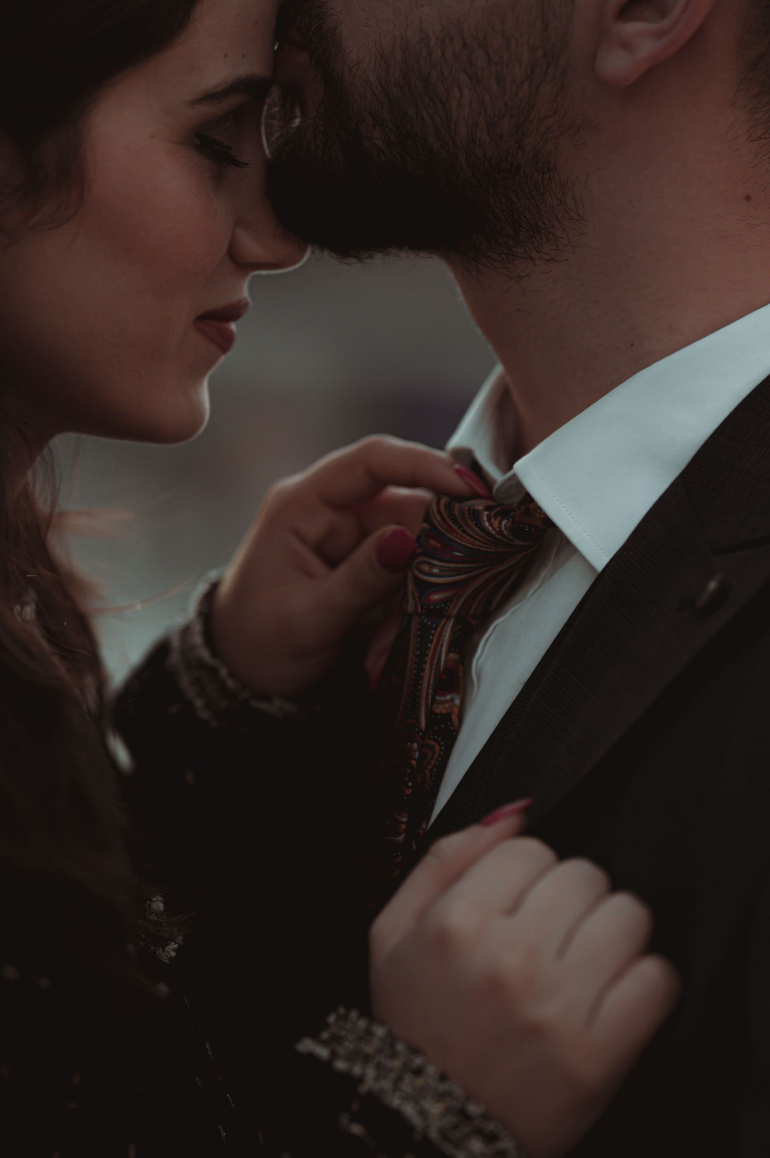 Romantic close-up portrait of a couple in formal attire sharing an intimate moment.