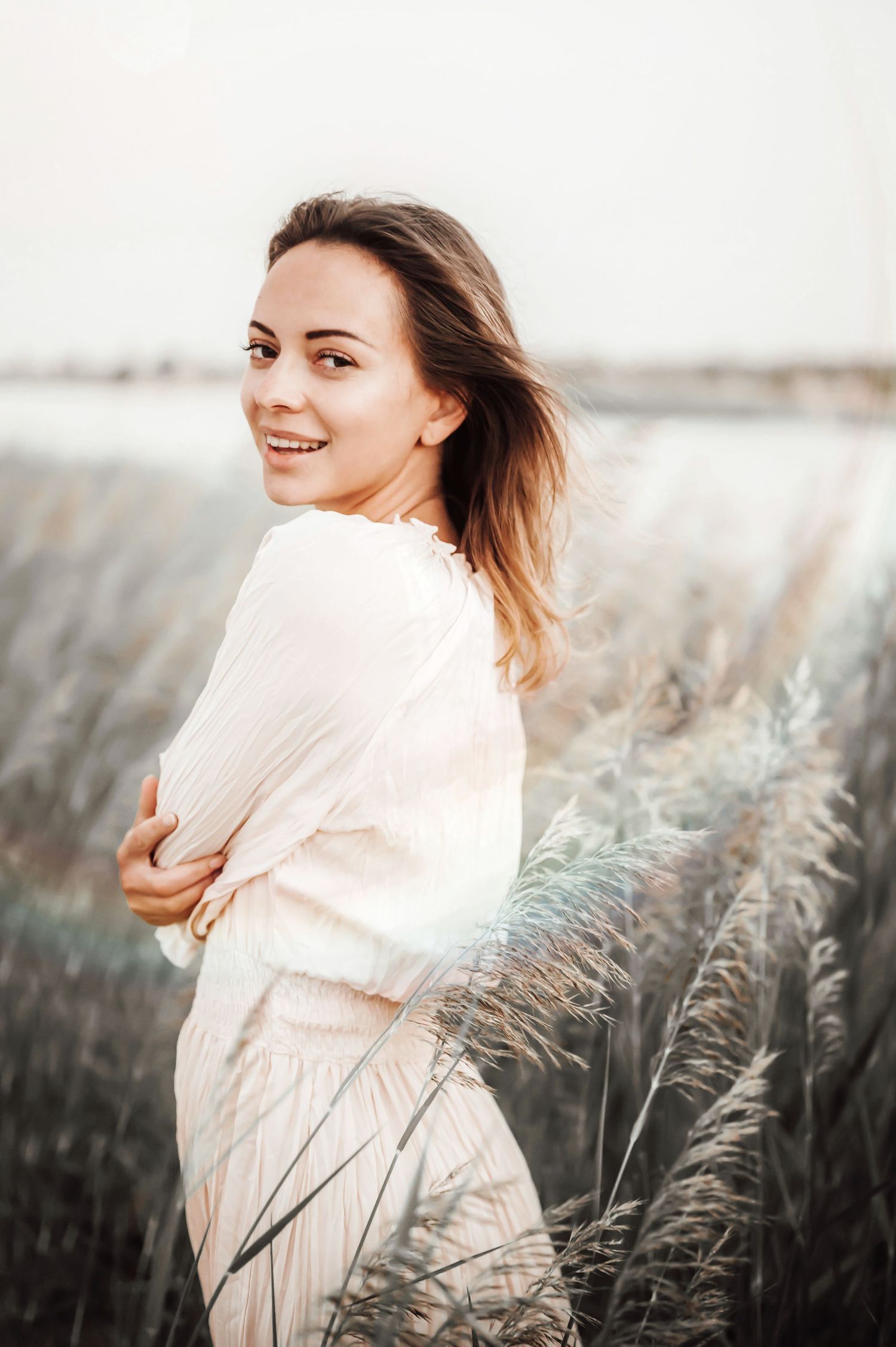 Candid movement portrait in a field of wheat with soft natural lighting.