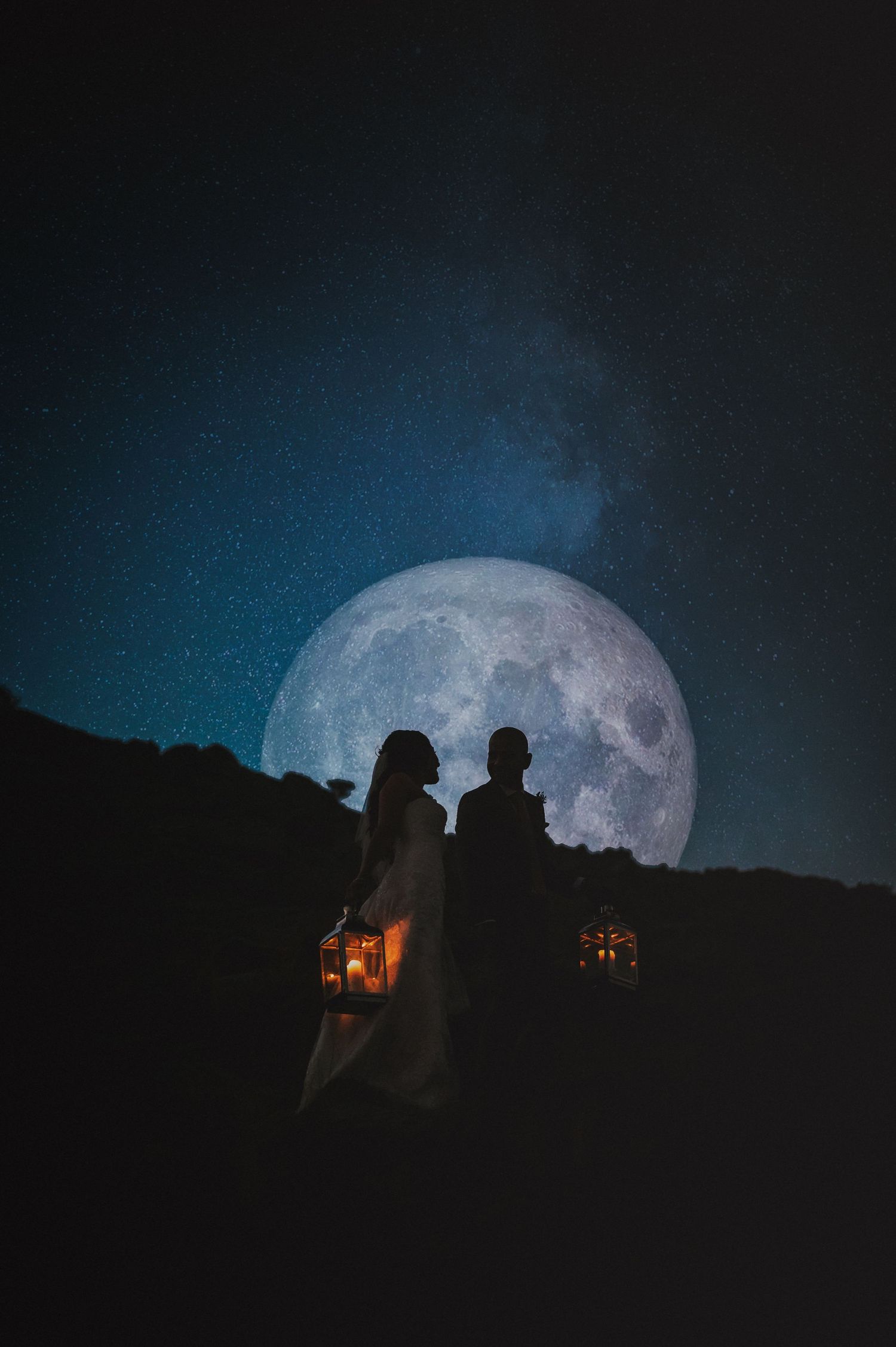 Full moon rising over desert landscape with lantern-lit silhouettes.