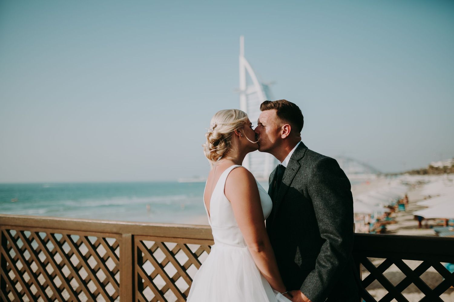 A romantic beachside wedding portrait with a wooden lattice backdrop.