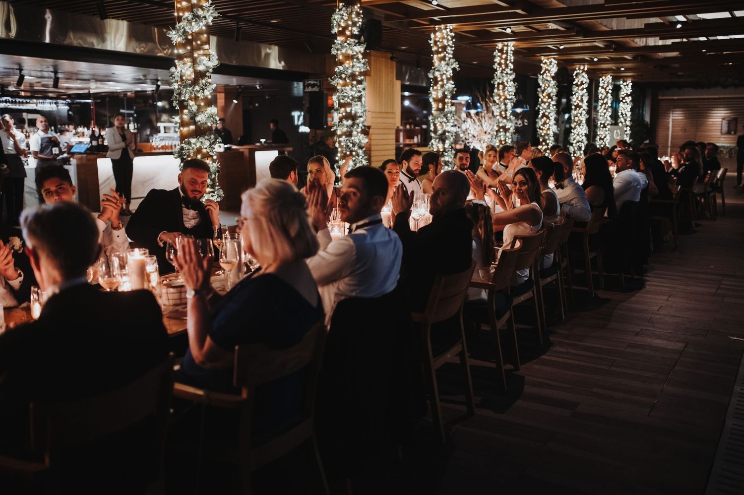 Dimly lit reception venue with hanging lights and decorative elements.