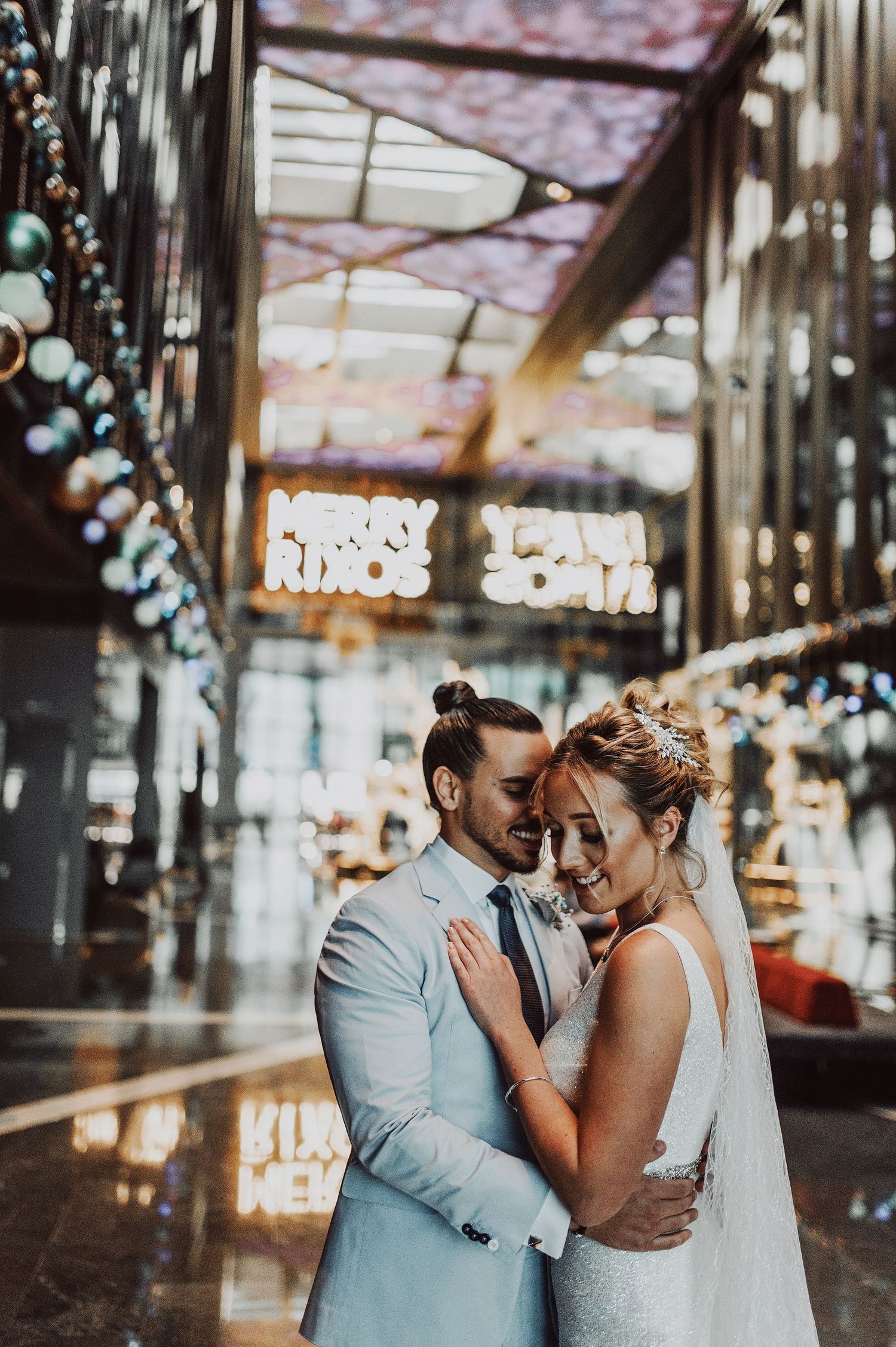 Couple sharing an intimate moment under twinkling lights in an indoor venue.