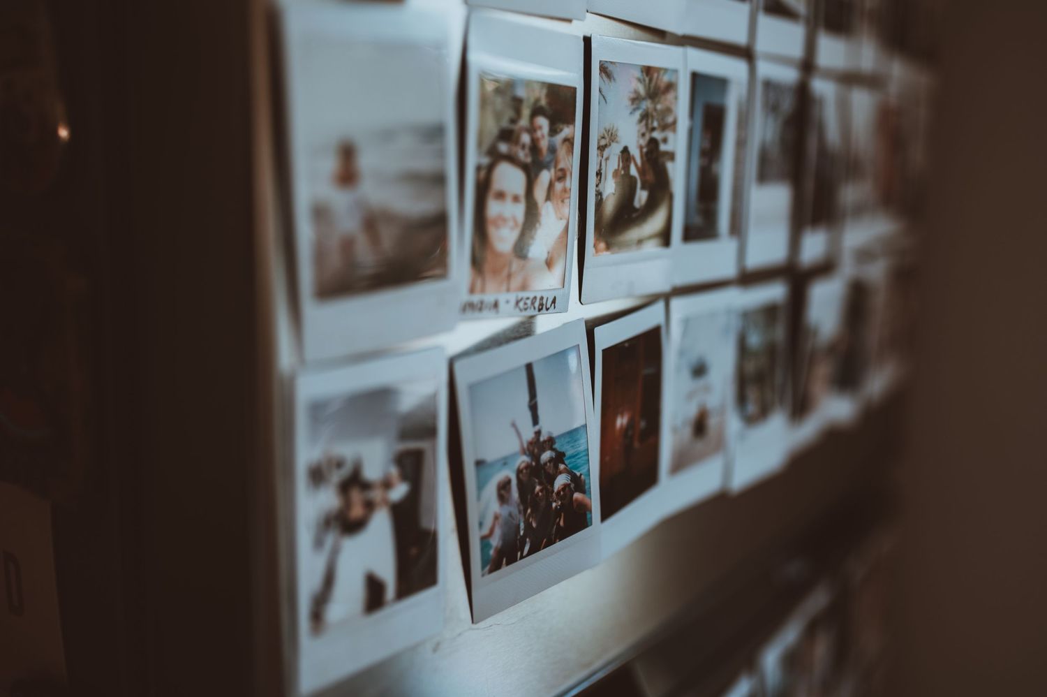 A wall of photographs displayed in dim lighting creating a gallery-like atmosphere.