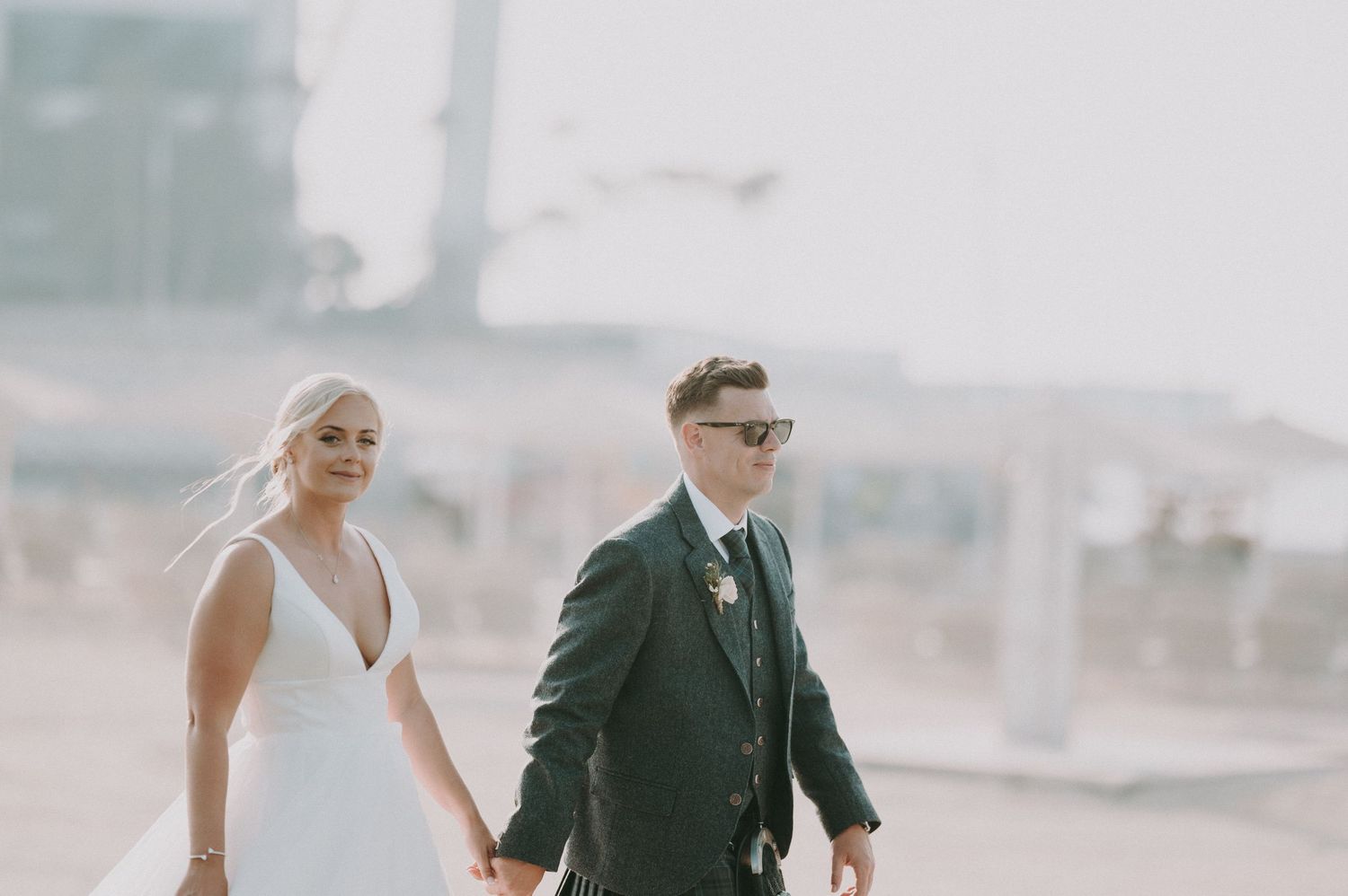 Candid wedding moment captured in bright desert setting.