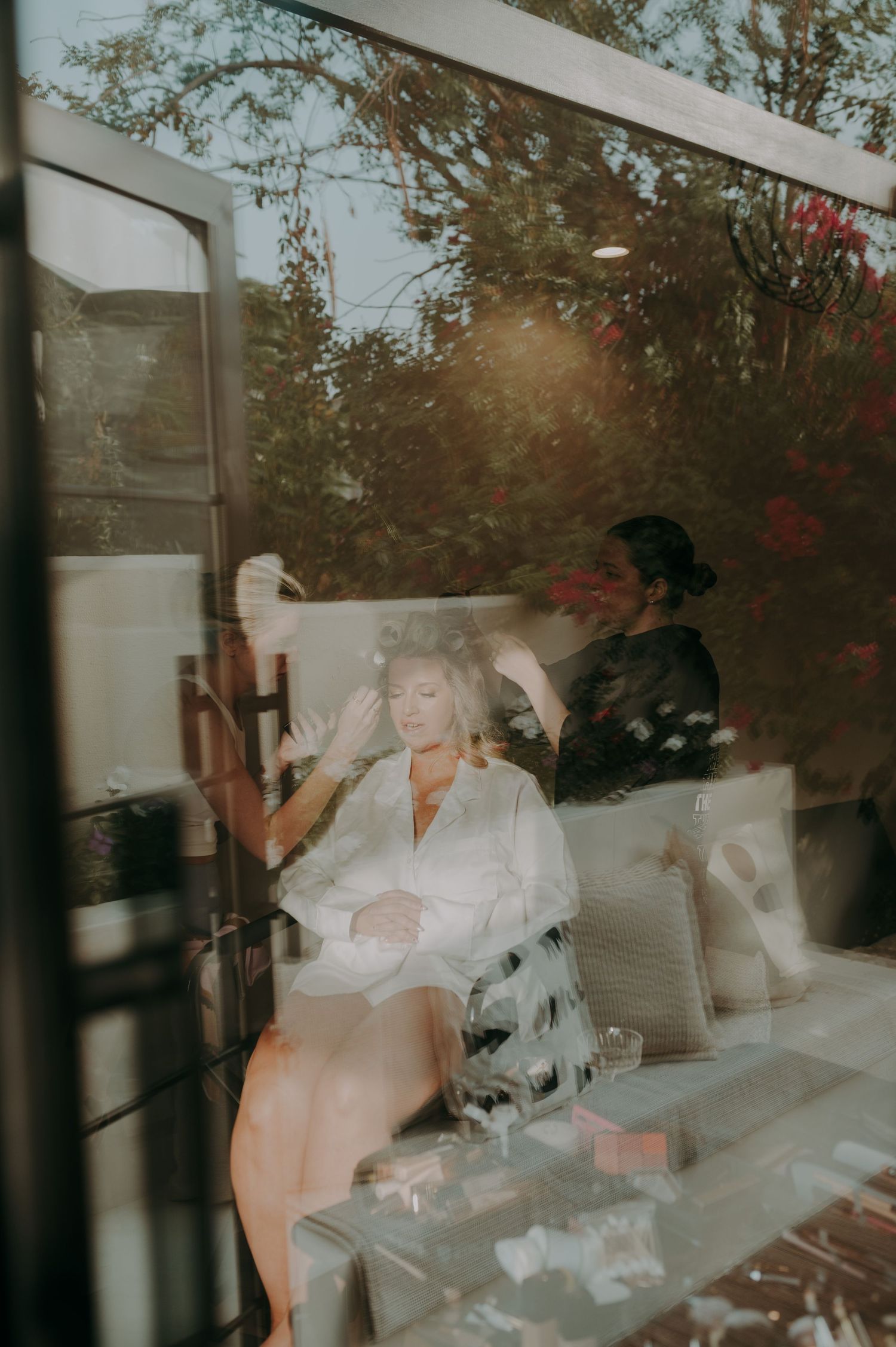 Dreamy window reflections showing figures in white through glass.