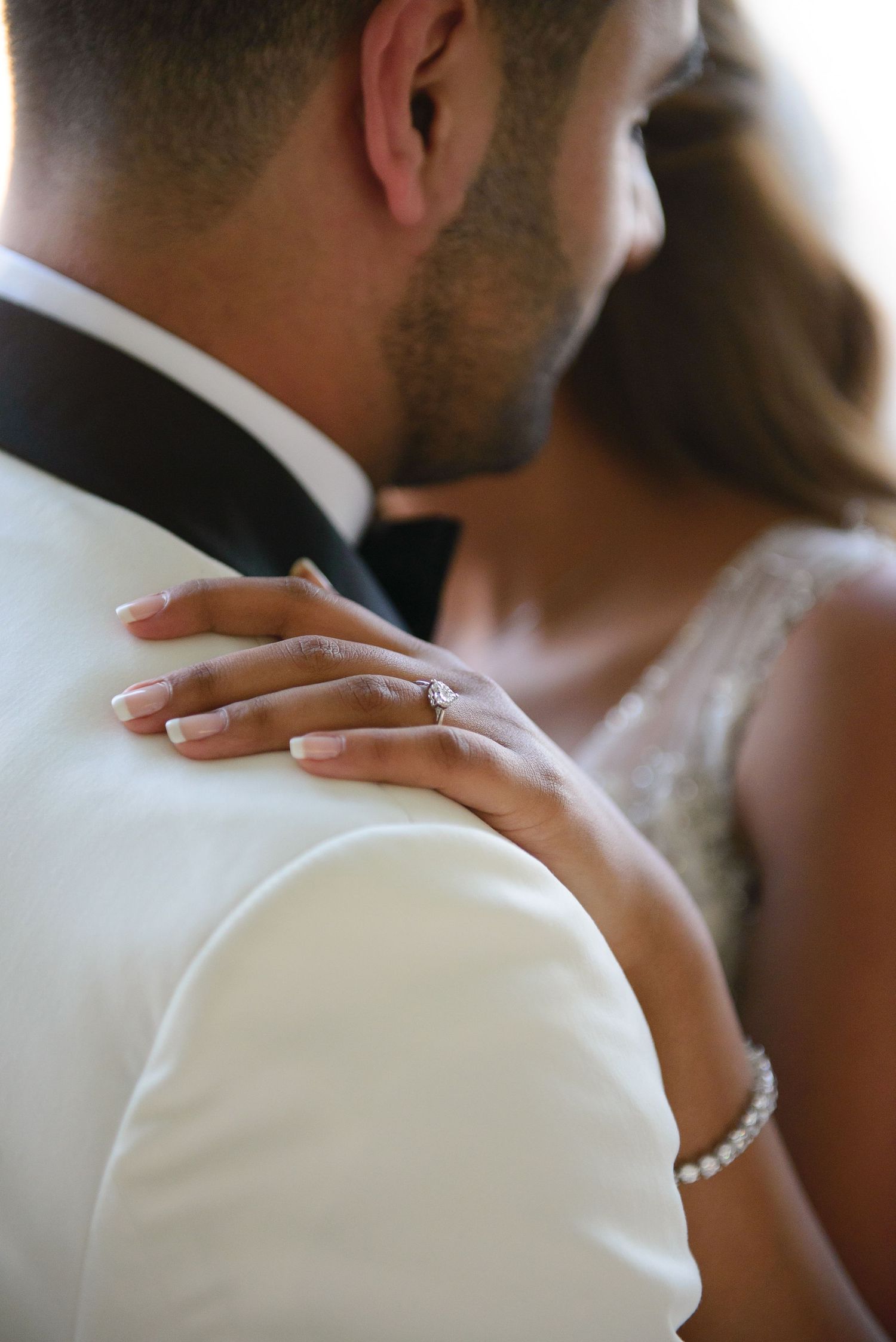 Close-up details of a bride and groom embracing during their wedding celebration.