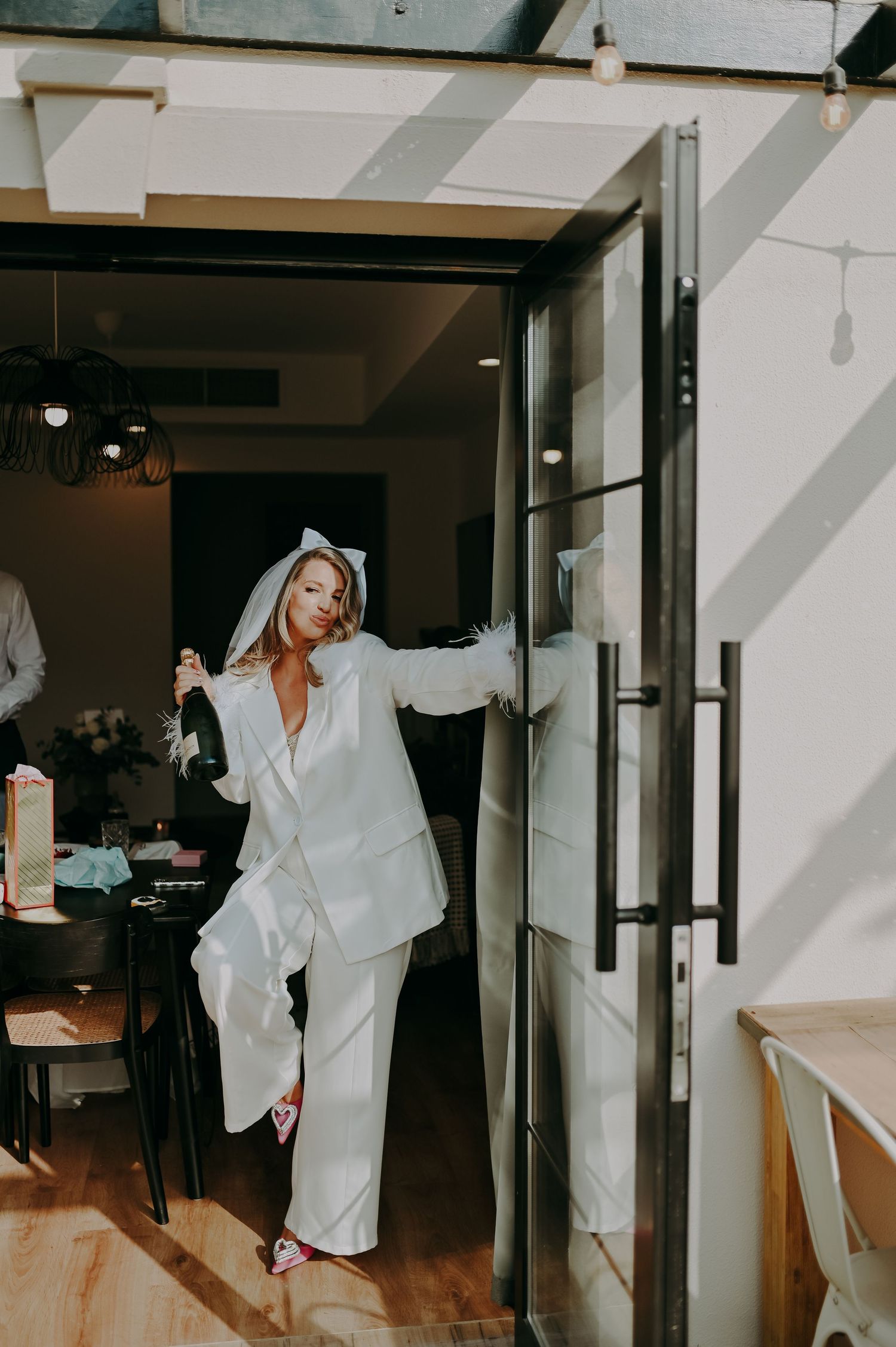 A series of artistic photos showing movement in a white robe against a dark interior space.