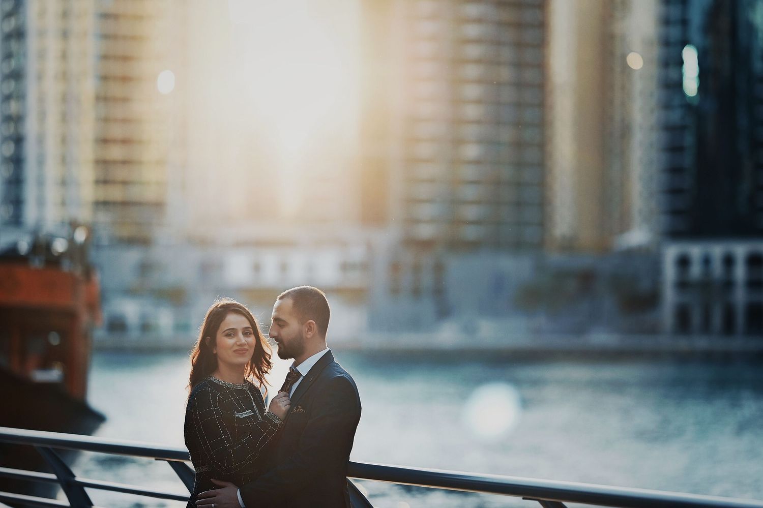 Romantic couple portrait with urban architecture and golden hour lighting.