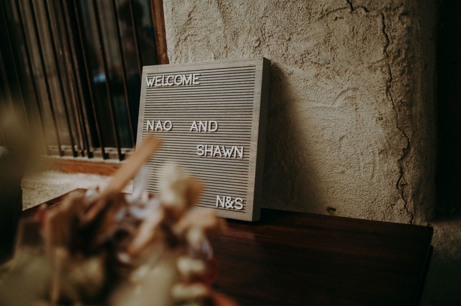 A vintage letter board displays wedding signage against a textured wall.
