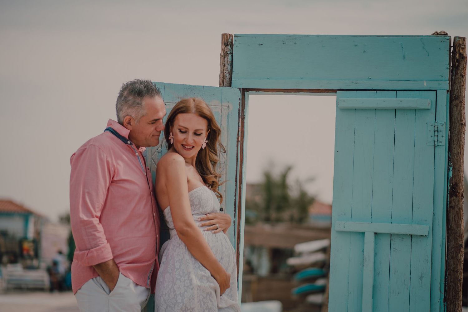 Romantic couple photos against turquoise wooden door backdrop.