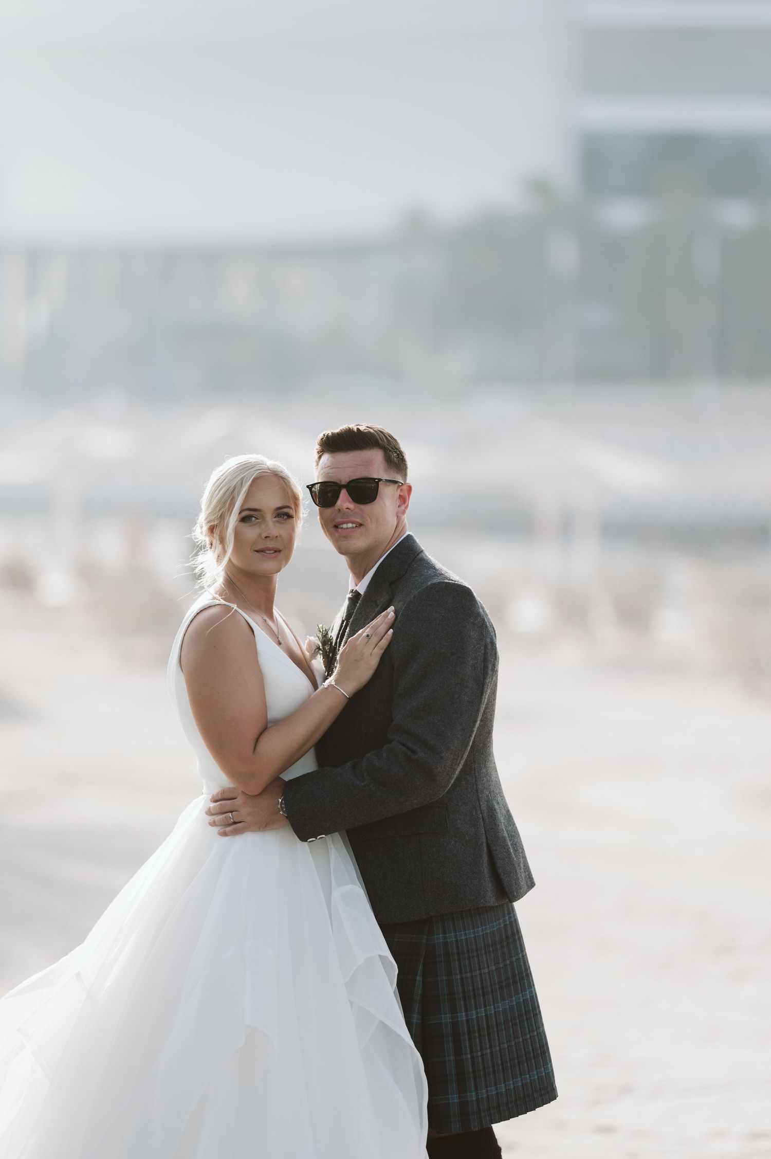 Romantic beach wedding photography featuring a couple in traditional formal attire.