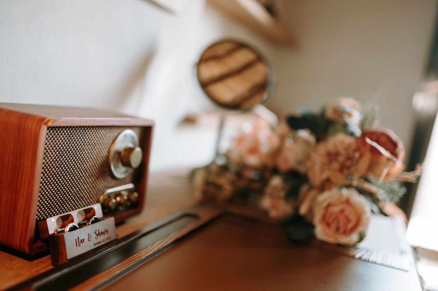 Wedding details including rings and floral arrangements captured in warm, moody lighting.